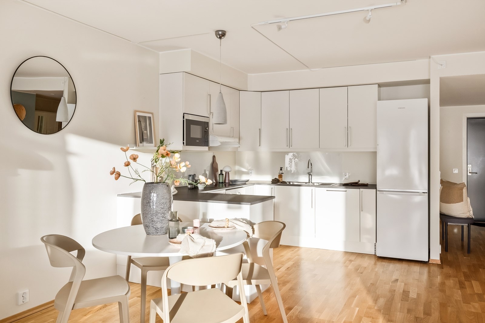 Denne åpne og tidløse kjøkkenløsningen kombinerer funksjonalitet med et lyst og harmonisk uttrykk. Kjøkkenet er integrert i oppholdsrommet på en naturlig måte, noe som skaper en sosial og inkluderende atmosfære. Galleribilde