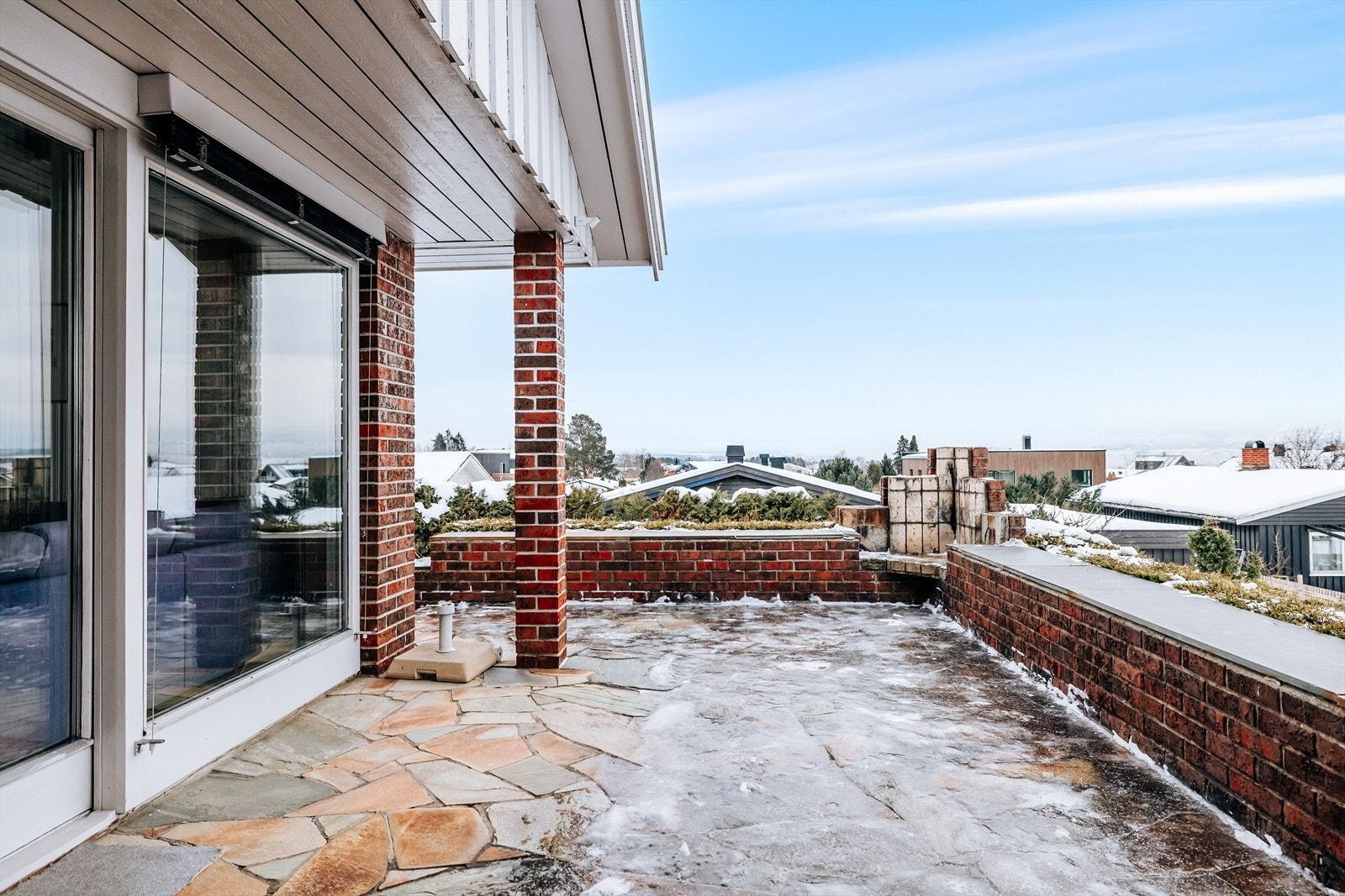 Fra stua er det utgang via skyvedør til denne romslige uteplassen. Den er belagt med steinheller og har god plass til diverse utemøbler. Galleribilde