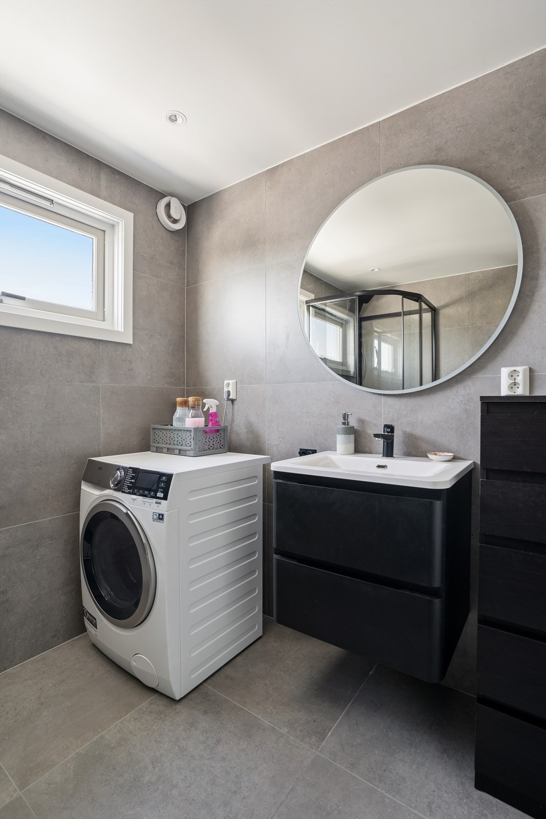 Badet er utstyrt med vegghengt toalett, dusjkabinett, baderomsinnredning med servant, samt opplegg for vaskemaskin. Galleribilde