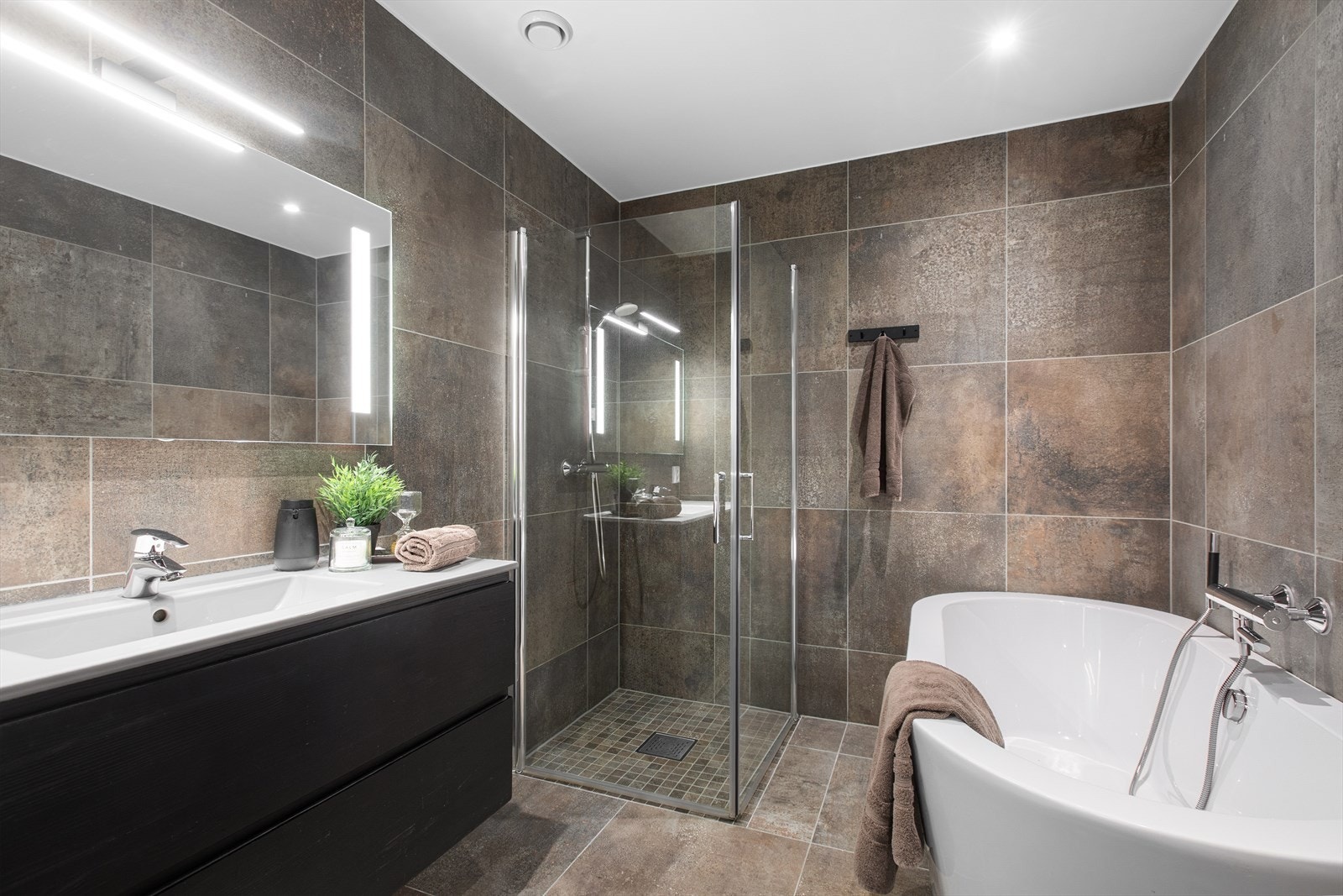 Hovedbadet er velutstyrt med både badekar og dusjhjørne, samt varmekabler i gulvet. Galleribilde