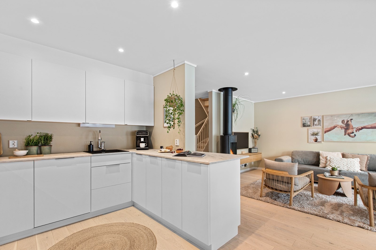 En stilren vedovn er plassert sentralt i rommet og gir både varme og hygge. Galleribilde