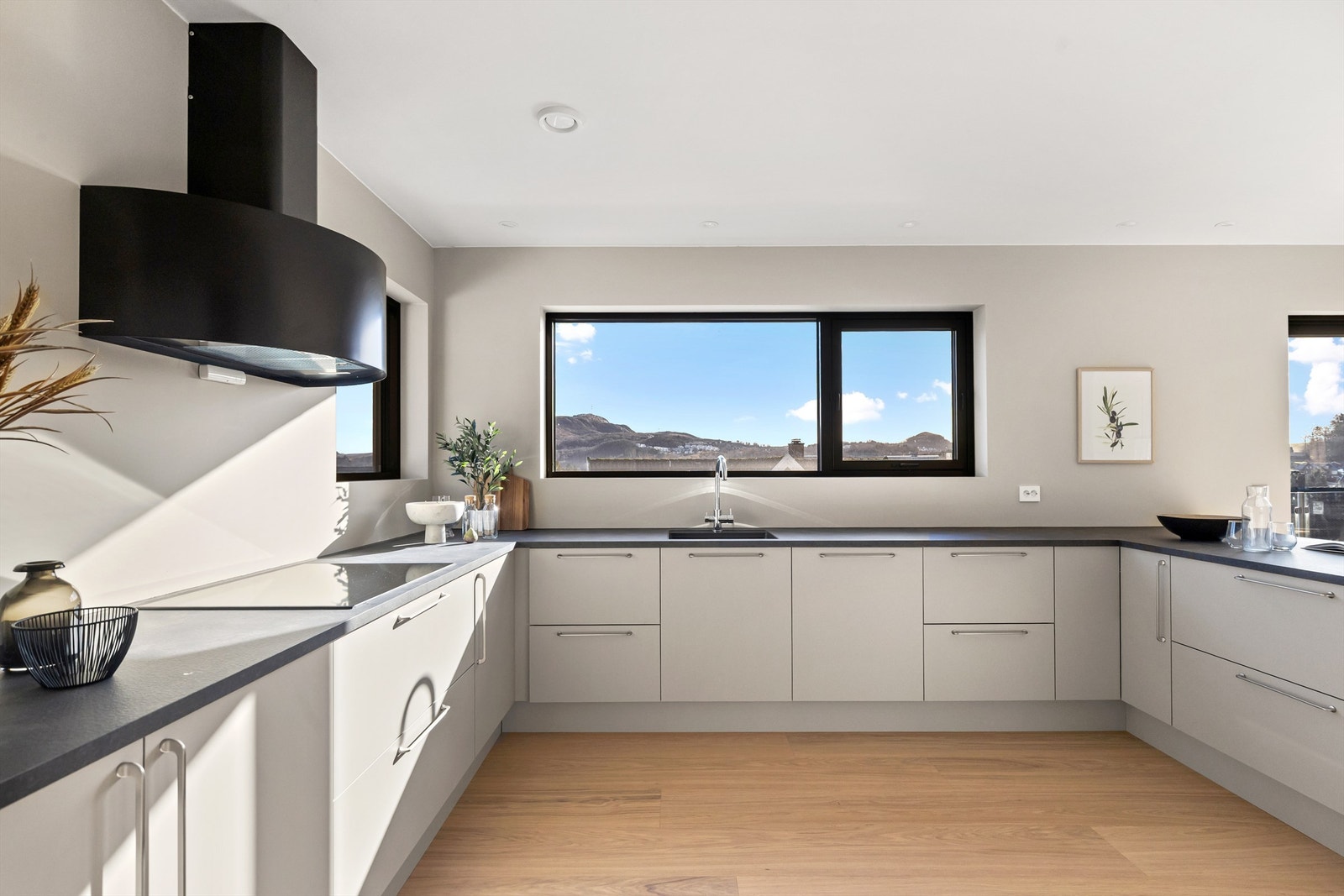 Kjøkkenet har en moderne innredning med slette fronter og rikelig med skapplass. Galleribilde