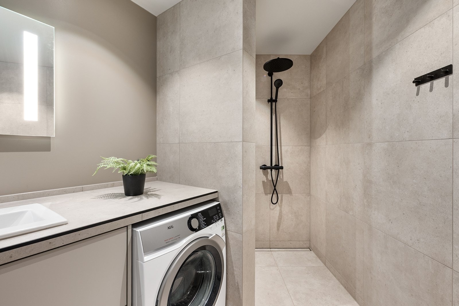 Spesial tilpasset benkeplate i flis med nisje for vask/tørk under, samt generøs dusjsone. Galleribilde