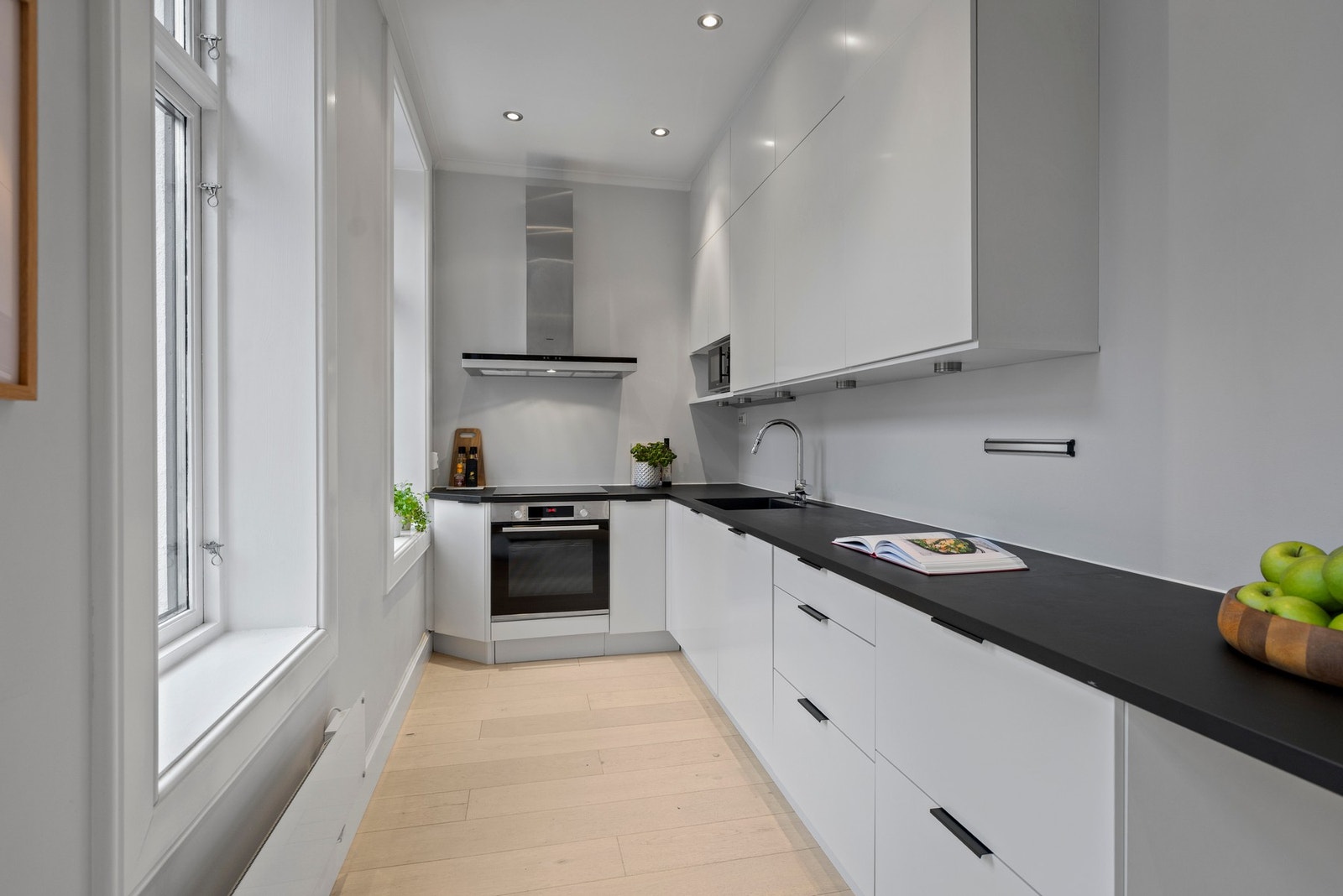 Kjøkkenet fremstår moderne og funksjonelt, med downlights i himling som, i kombinasjon med store vindusflater, gir rikelig med arbeidslys. Galleribilde