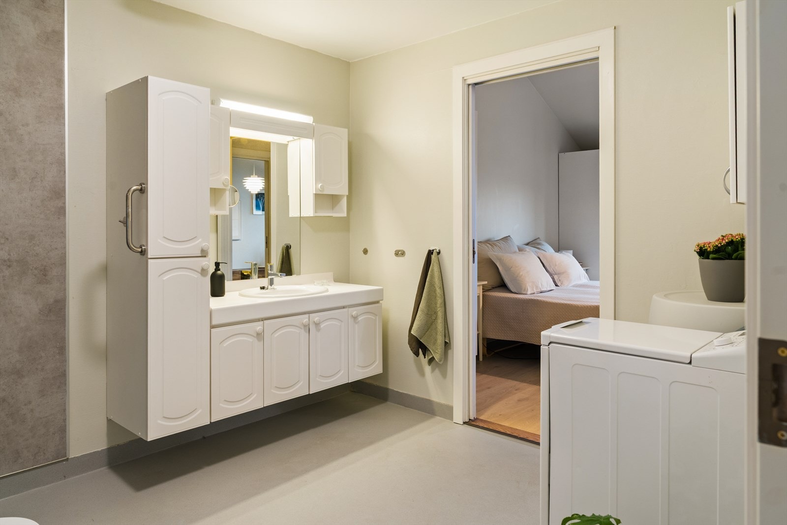 Romslig bad utstyrt med nedfelt servant, toalett, dusjvegger og opplegg for vaskemaskin Galleribilde