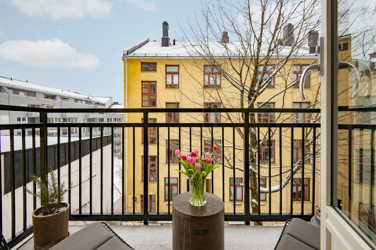 Balkongen er vendt mot en grønn og innbydende bakgård, som gir en skjermet og behagelig ramme rundt uteplassen. Galleribilde