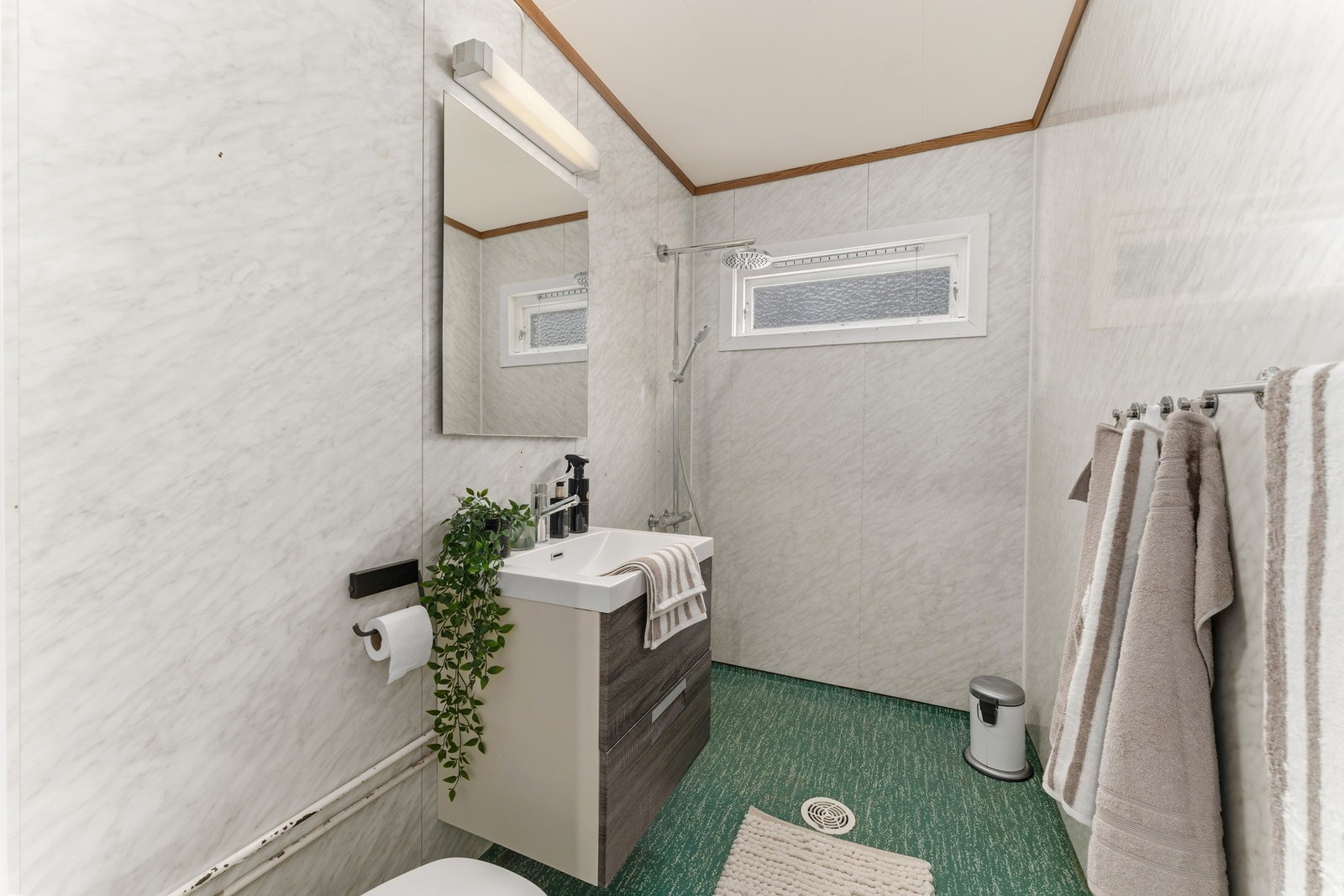 Bad fra byggeår. Badet har toalett, servant med innredning og dusjløsning Galleribilde