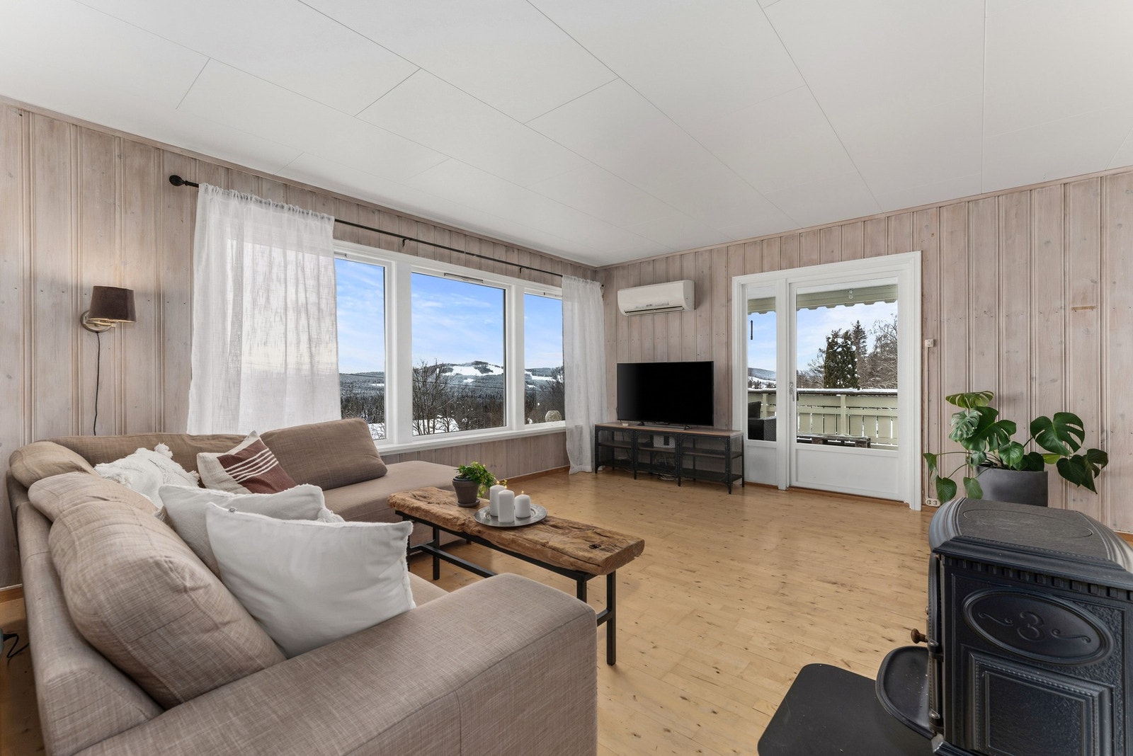 Romslig og lys stue med store vindusflater Galleribilde