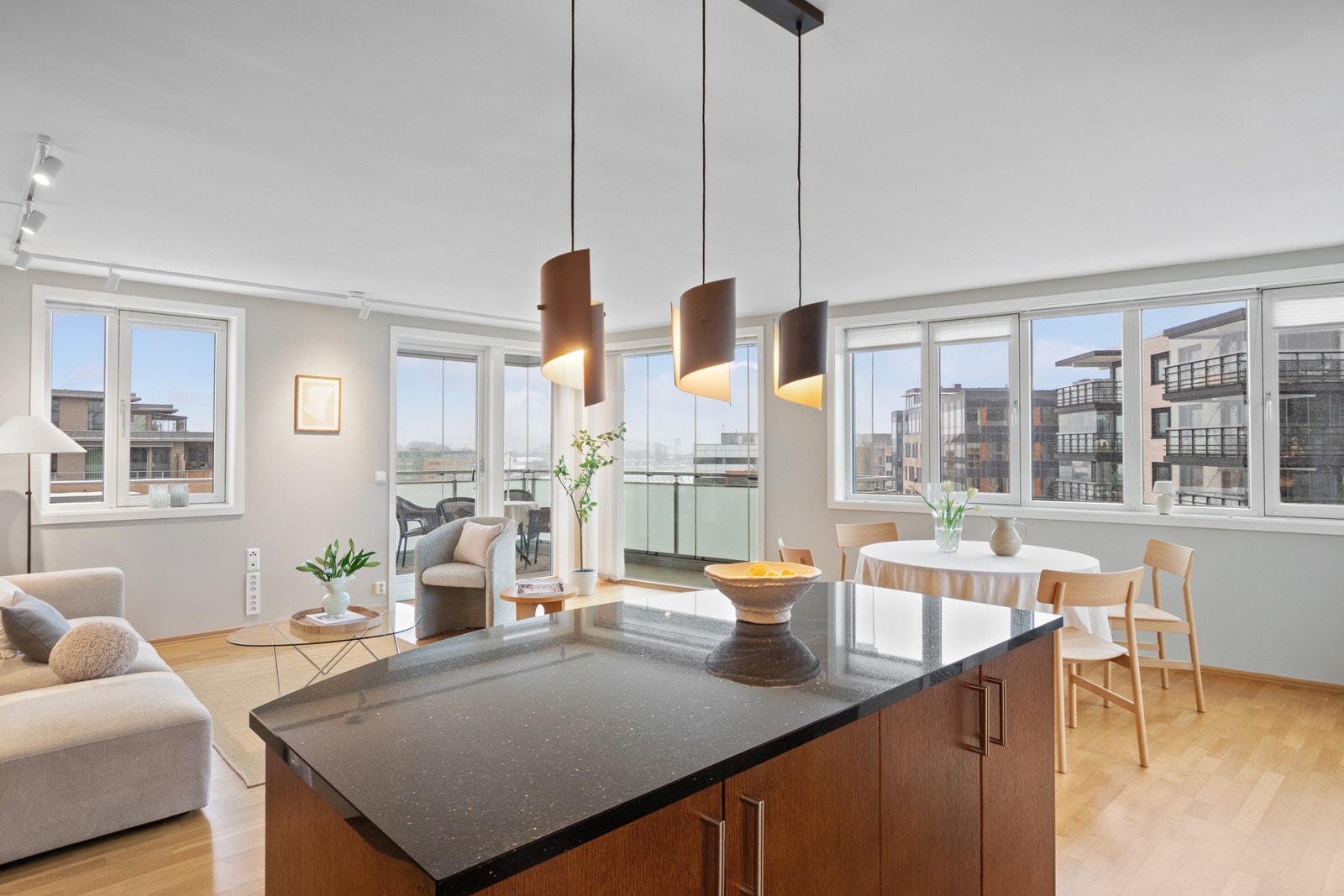 På kjøkkenøya er det sort plate i stein, og langs veggen er det sort laminatbenkeplate med nedfelt kum i stål Galleribilde