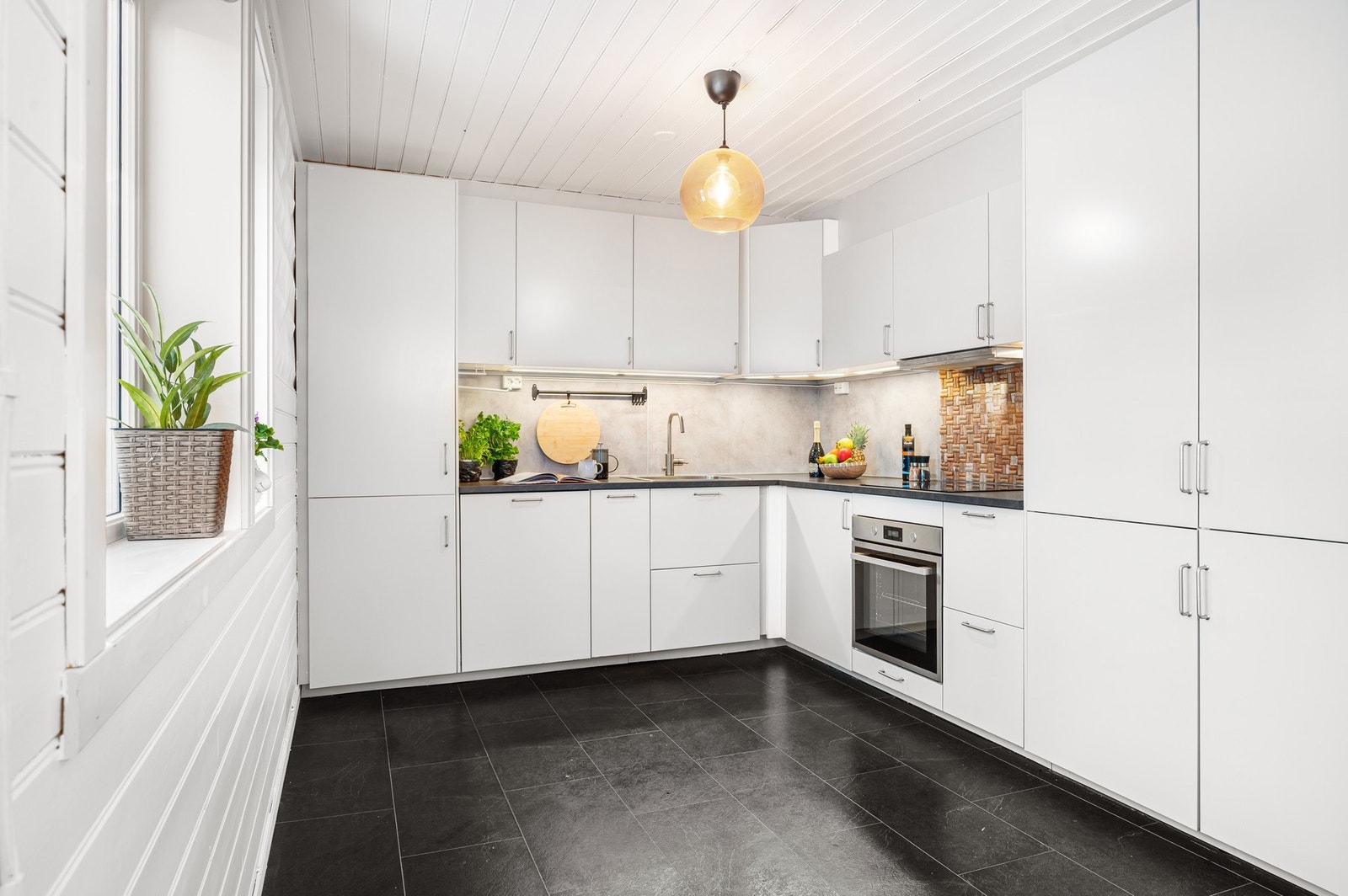 Flott og lyst kjøkken med mye skap og benkeplass. Galleribilde