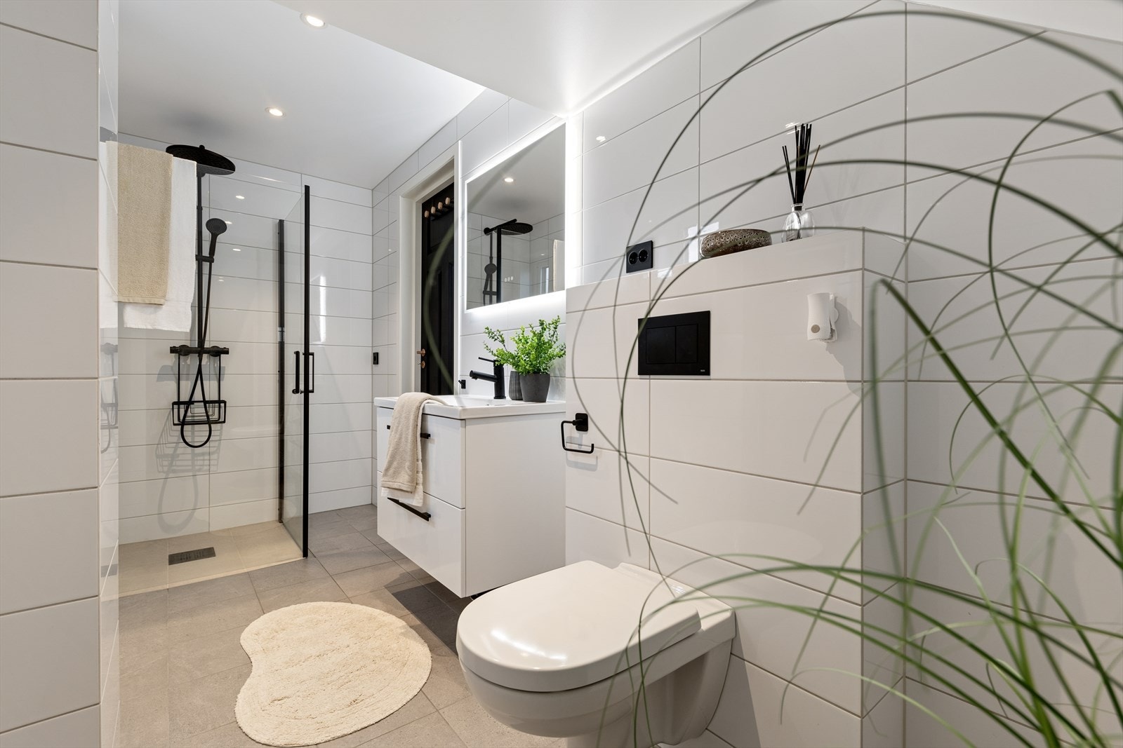 I første etasje finner du et baderom med dusj med glassdør og veggmontert toalett, utformet for å utnytte arealet på en praktisk måte. Galleribilde