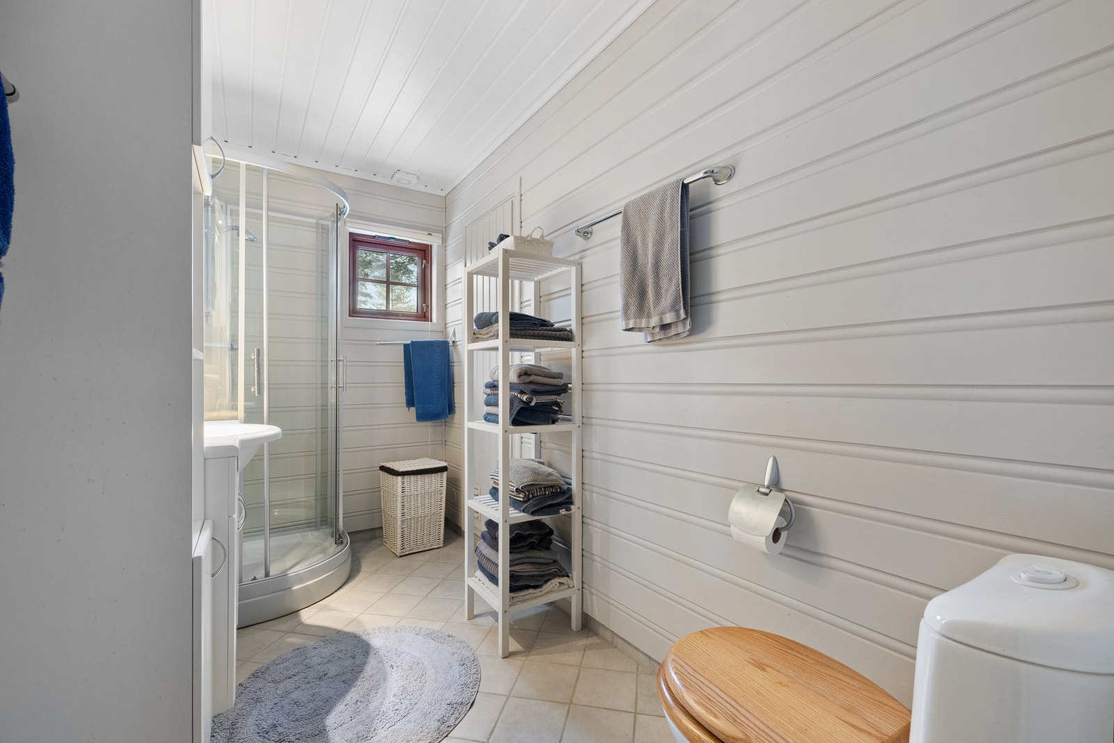 Det er varmekabler i gulvet og belysning over speil. Badet er innredet med toalett, dusjkabinett og servant, og fremstår som funksjonelt og praktisk. Galleribilde