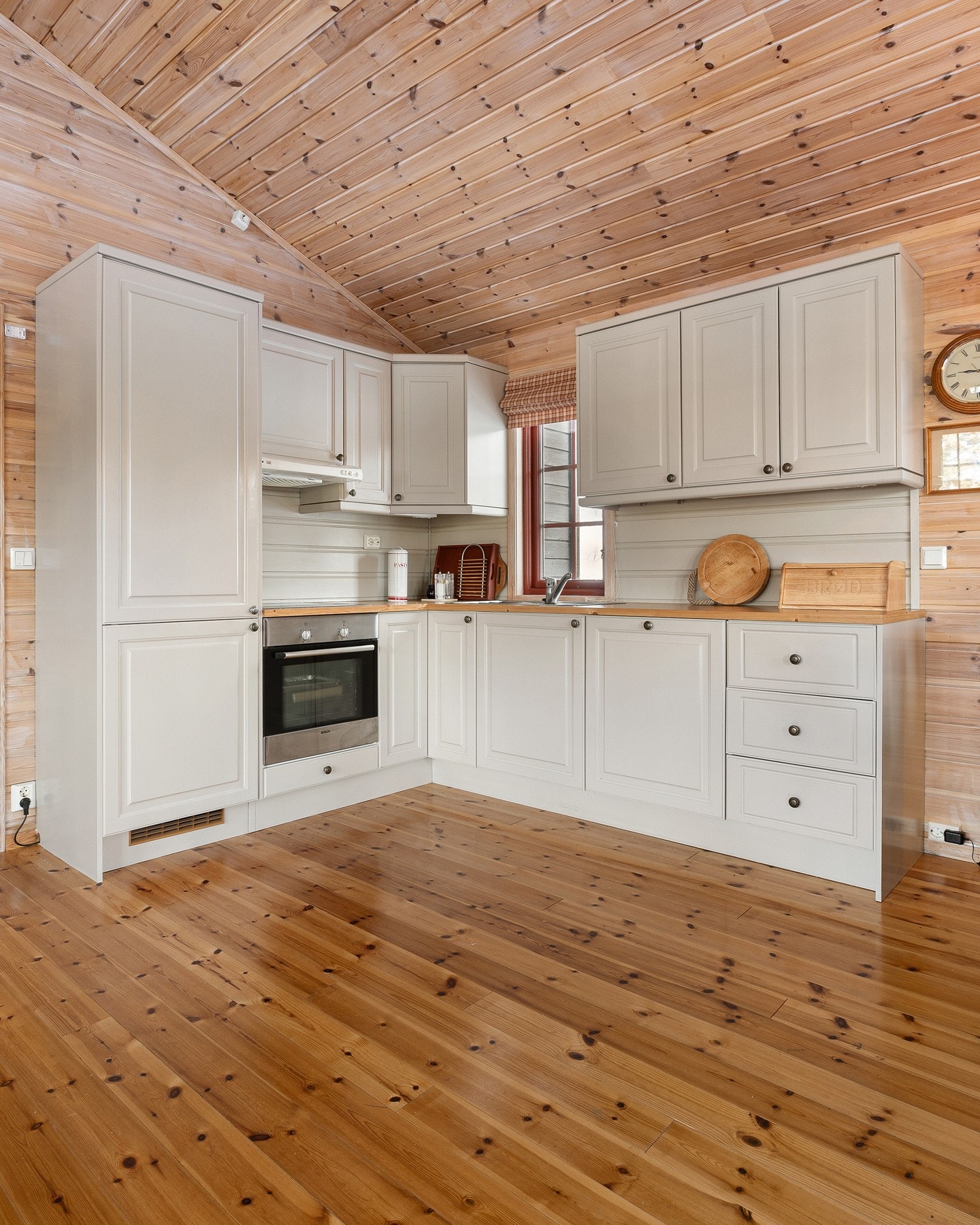 Kjøkkenet har innredning med klassiske, profilerte fronter og laminat benkeplate som gir en praktisk og slitesterk arbeidsflate. Galleribilde