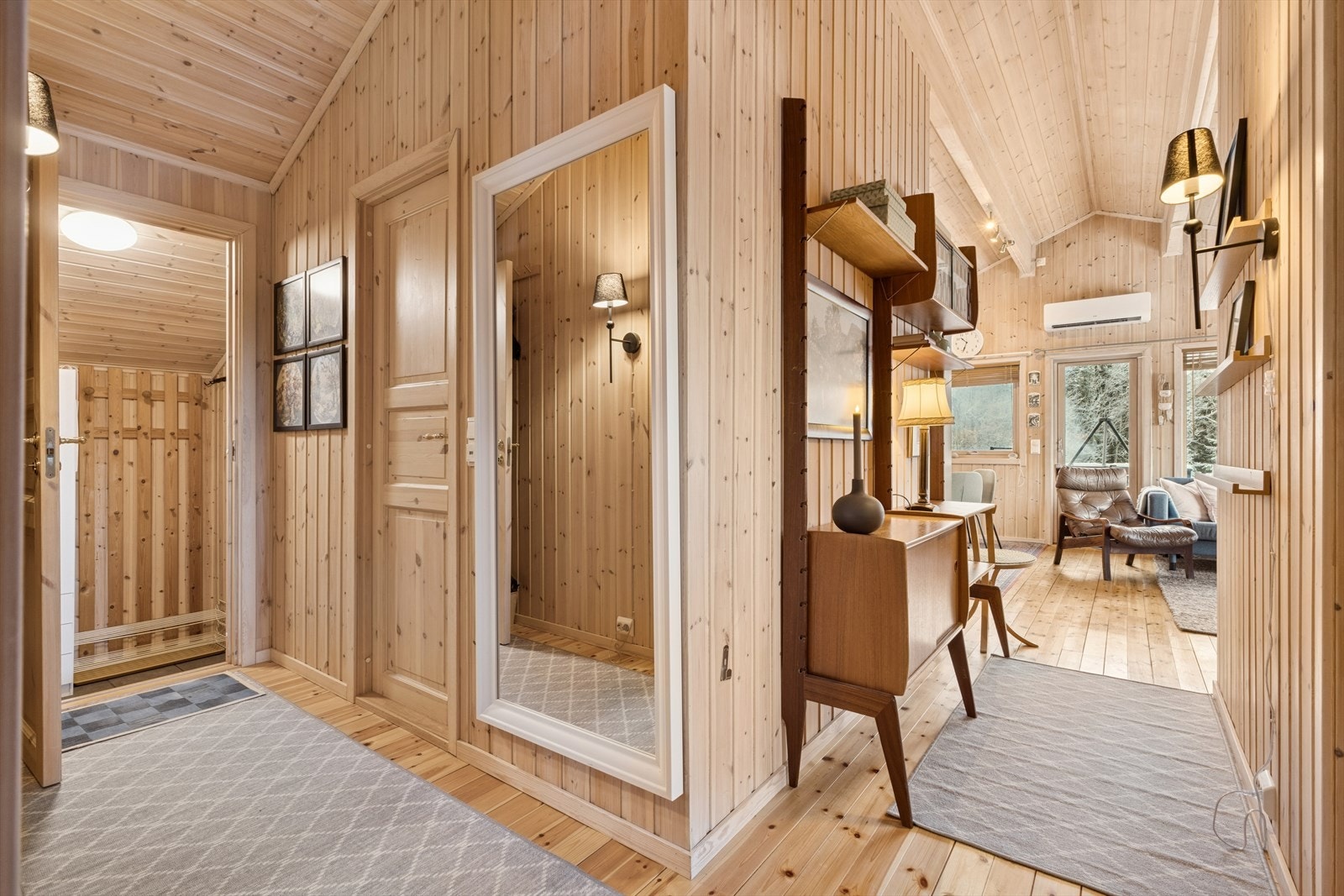 Vegger og tak er kledd med trepanel, som gir et naturlig preg til rommet. Galleribilde