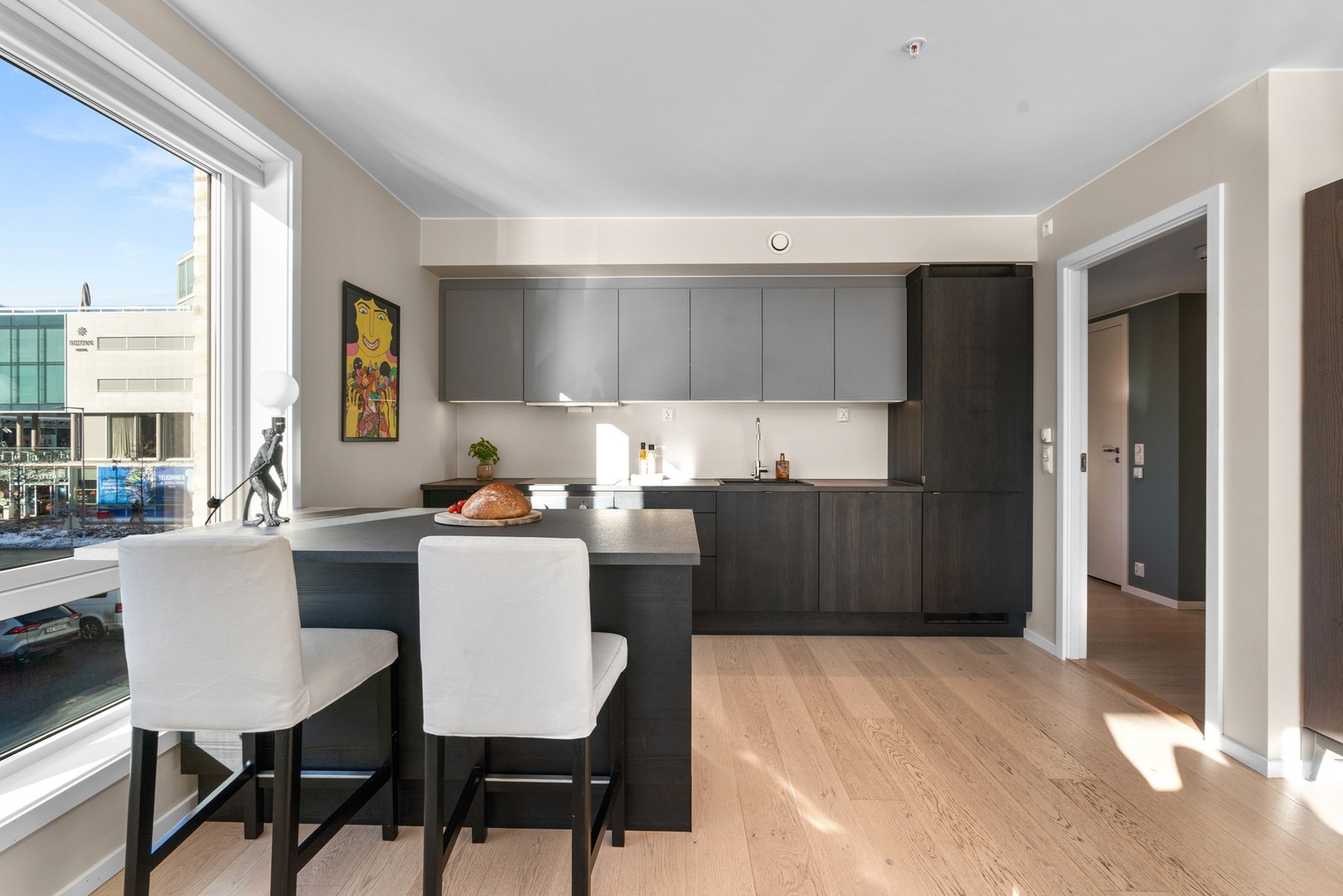 Stilfull kjøkkenøy med barbordløsning skaper et naturlig skille i rommet. Galleribilde