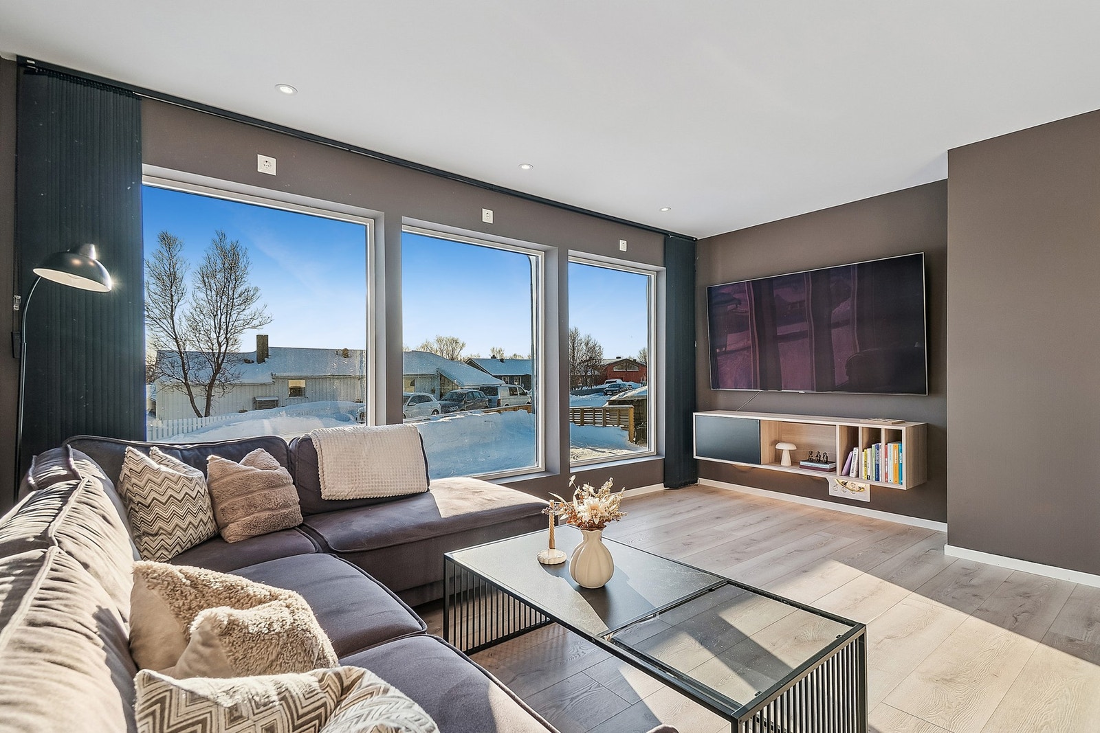 Stuen har store vindusflater som gir deg rikelig med lysinnslipp, noe som komplimenterer boligens moderne farge- og materialvalg. Galleribilde