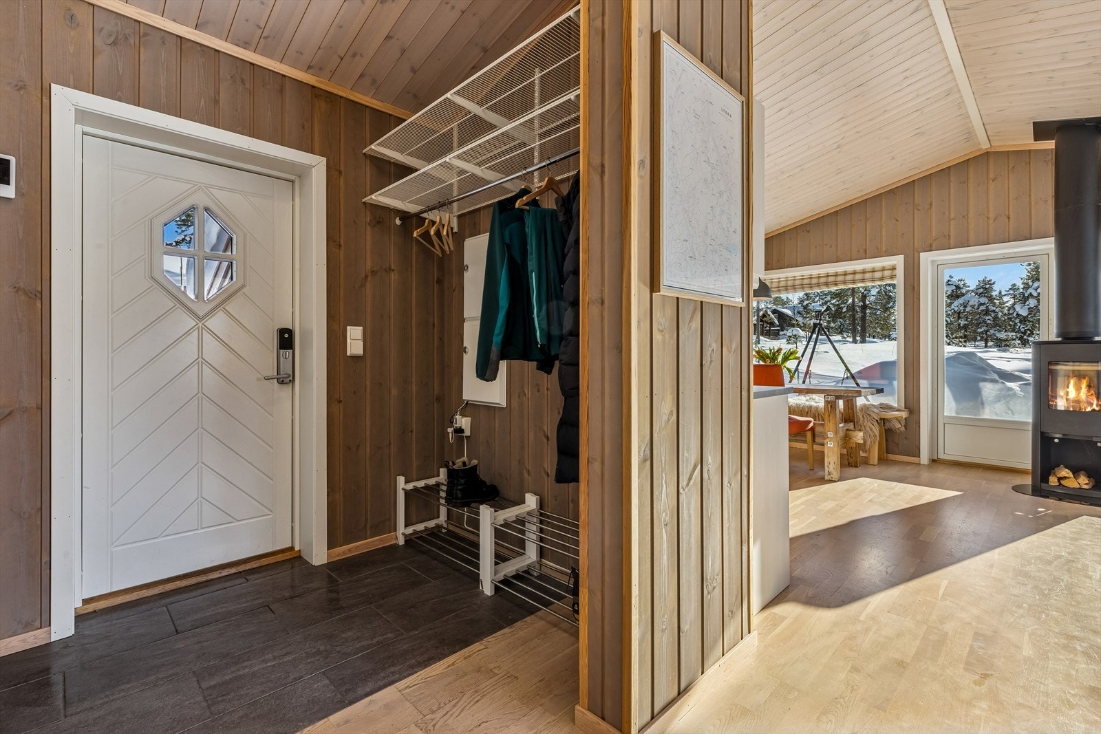 Entréen har flislagt gulv og praktisk oppbevaring for yttertøy. Galleribilde
