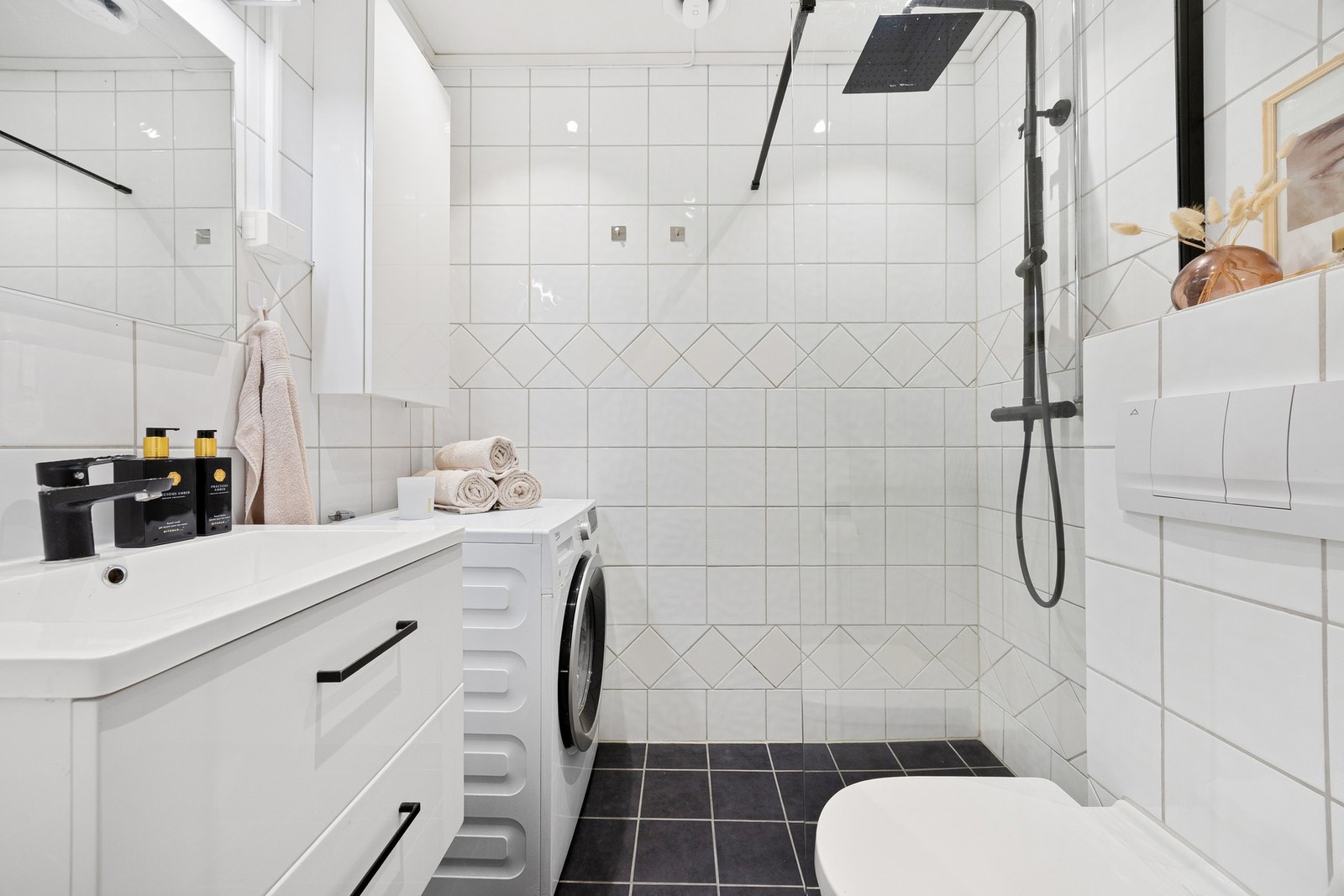 Flislagt bad med varmekabler i gulv og opplegg for vaskemaskin. Galleribilde