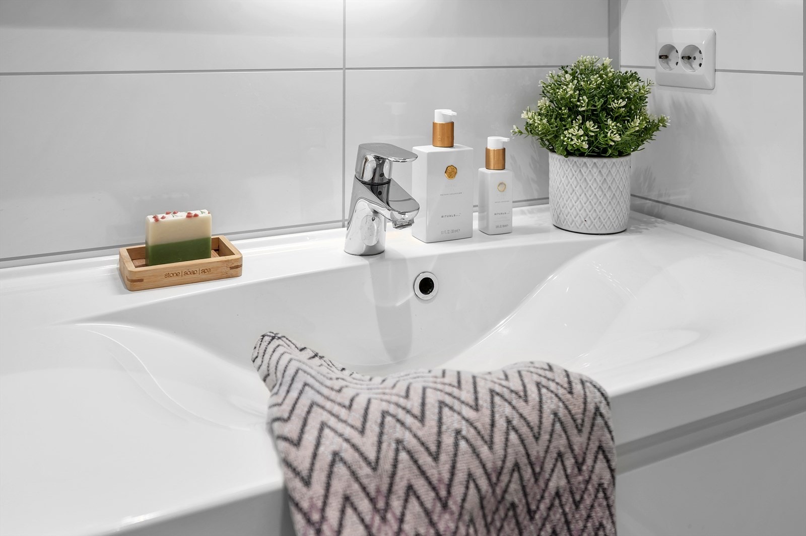 Rommet er utstyrt med en innredning med nedfelt servant, vegghengt toalett, badekar samt dusjhjørne med glassvegger. Galleribilde