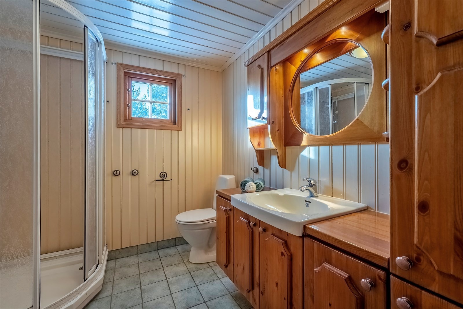 Badet har flislagt gulv med undervarme og opplegg for vaskemaskin Galleribilde