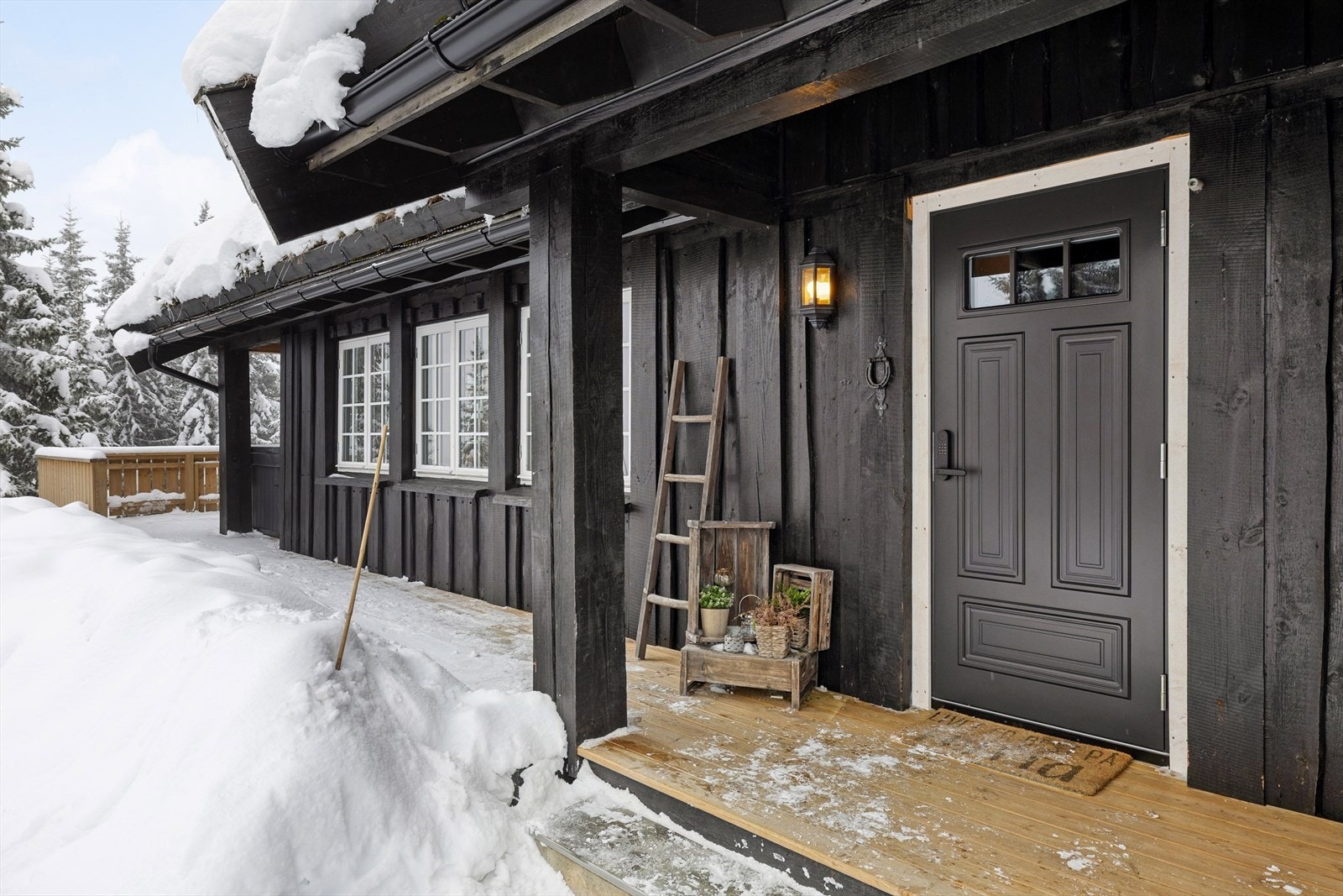 Delvis overbygd inngangsparti med treplatting som strekker seg rundt kortsiden av eiendommen Galleribilde