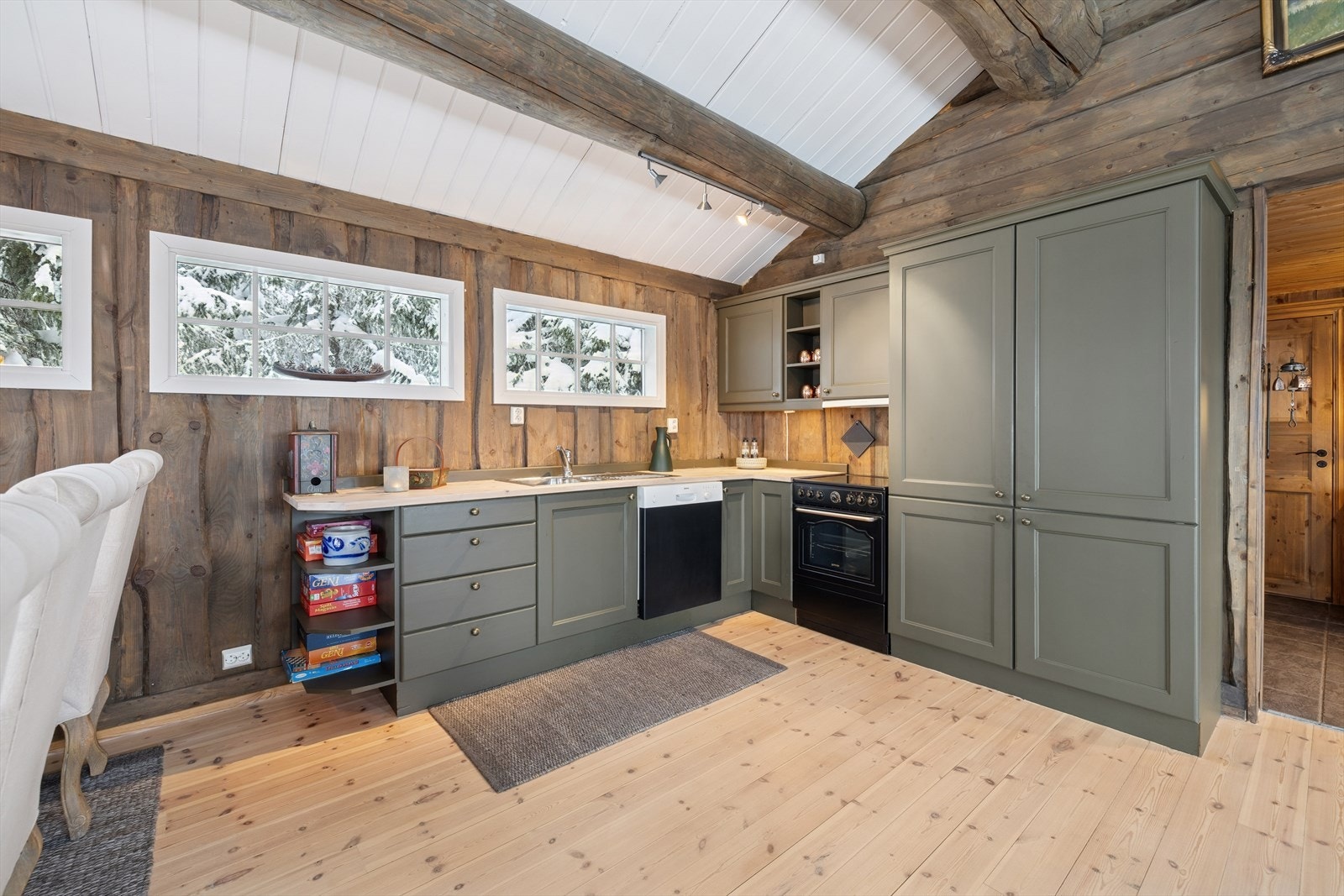 Kjøkkenet har malte, profilerte fronter, heltre benkeplate med nedfelt oppvaskkum, oppvaskmaskin, stekeovn, ventilator og kjøl/frys Galleribilde