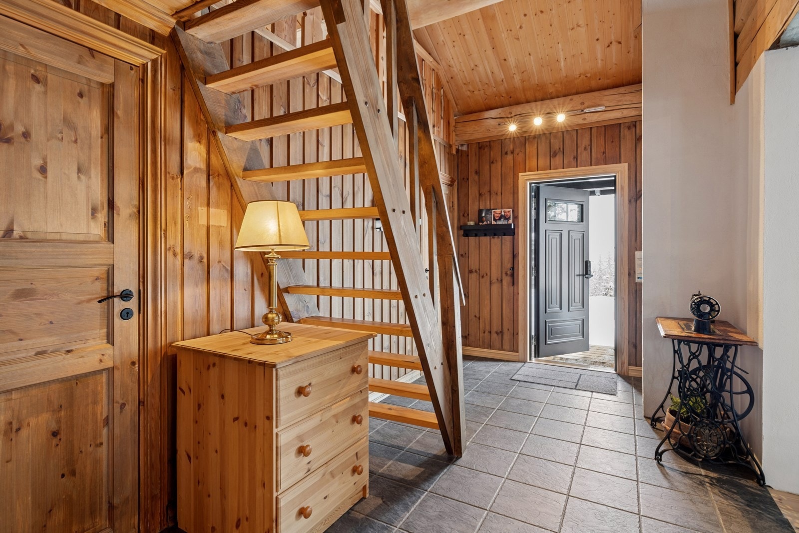 Velkommen inn! Romslig hall som er pent innredet med fliser på gulv med underliggende varme og god plass for knaggrekke Galleribilde