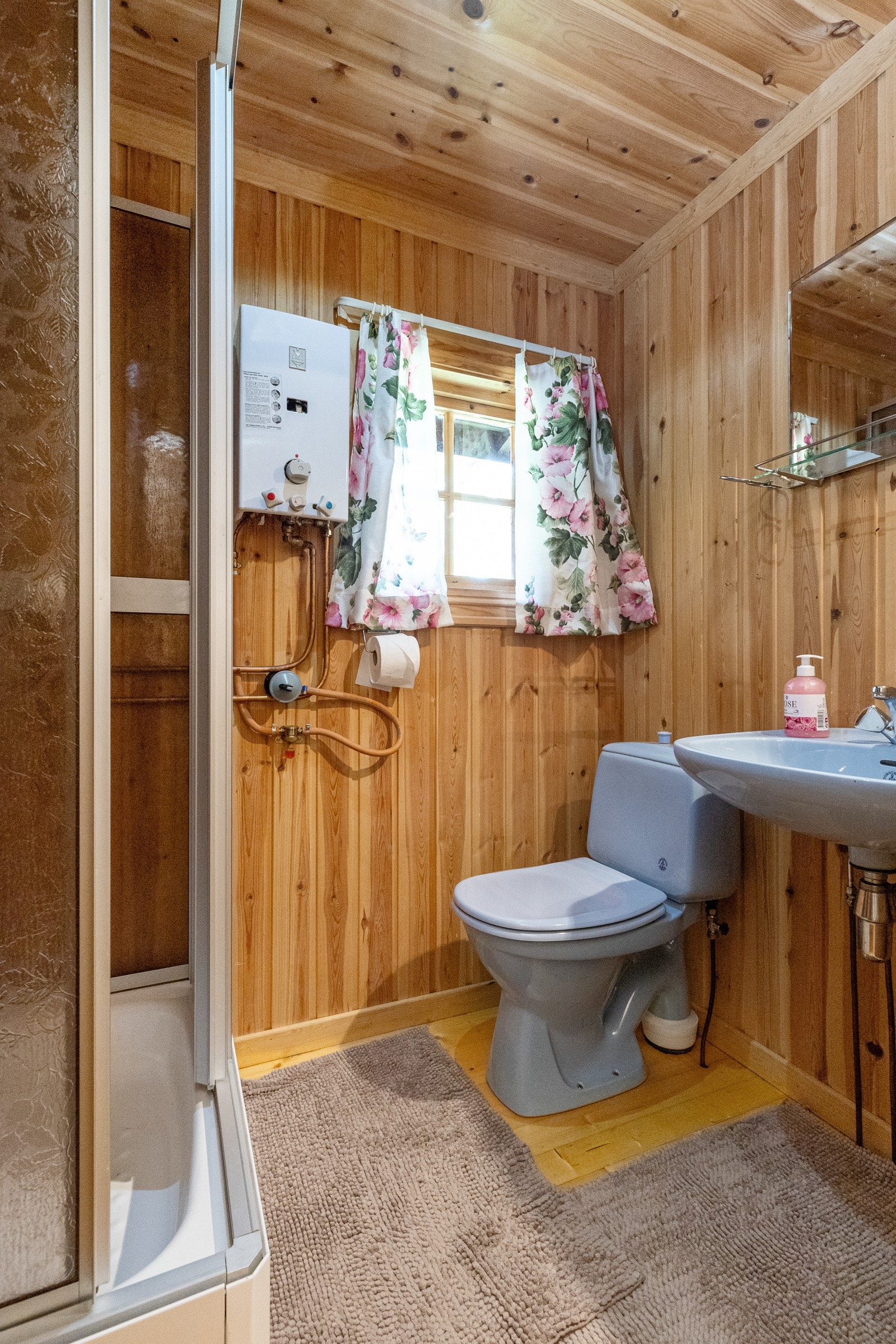 Hytta har 2 bad. Dette badet er i 1. etasje og inneholder servant, dusjkabinett og toalett Galleribilde