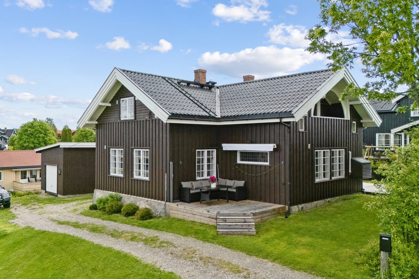 Fra hagen går det trapp opp til en lun, vestvendt terrasse på ca. 11 kvm fra 2023. Galleribilde