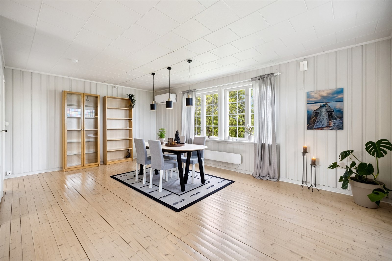 Dagslyset strømmer inn via store vinduer i spisestuen. Galleribilde