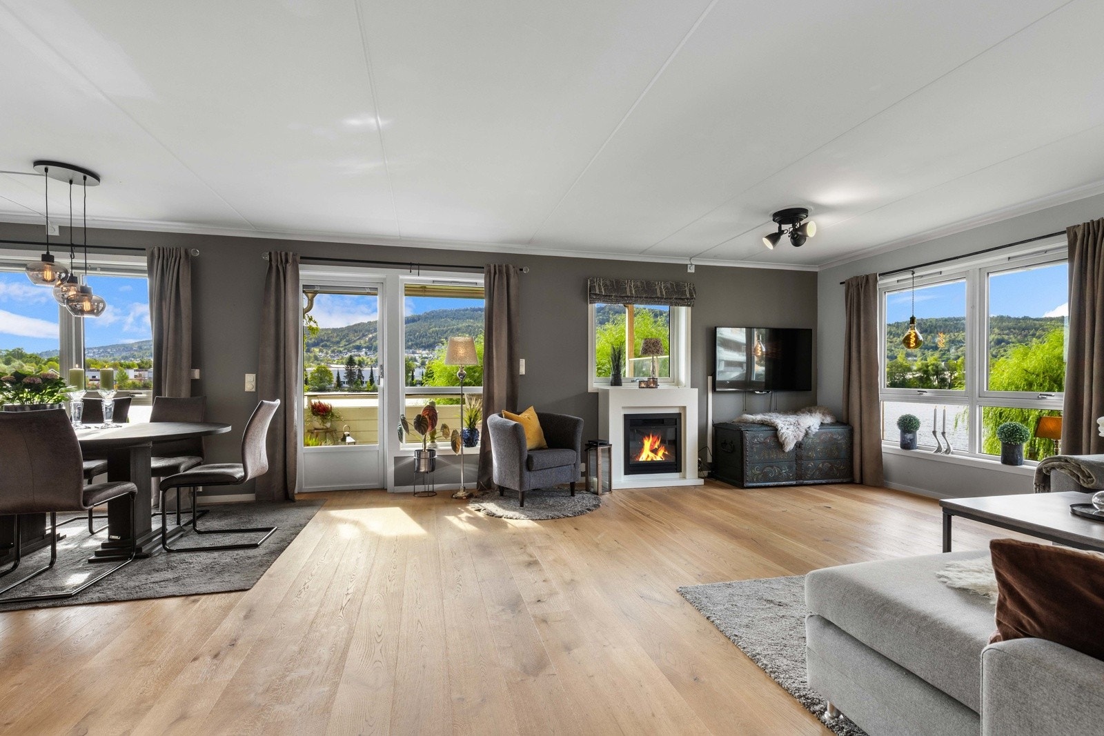 Romslig stue med store vinduer, naturlig lysinnslipp og fantastisk utsikt mot elven. Galleribilde