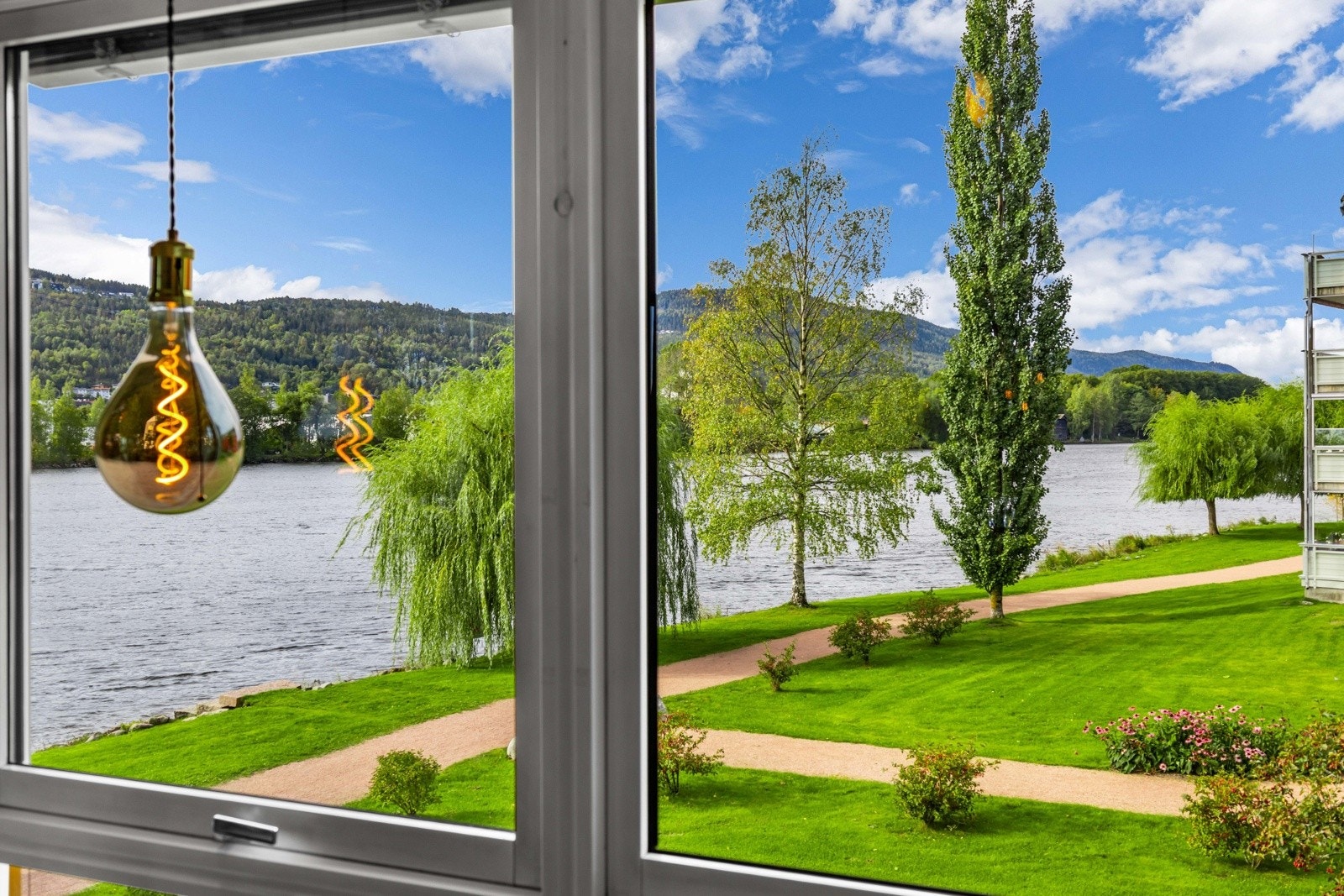 Fra stuen har du en levende utsikt rett ut mot elven og de frodige grøntområdene. Galleribilde