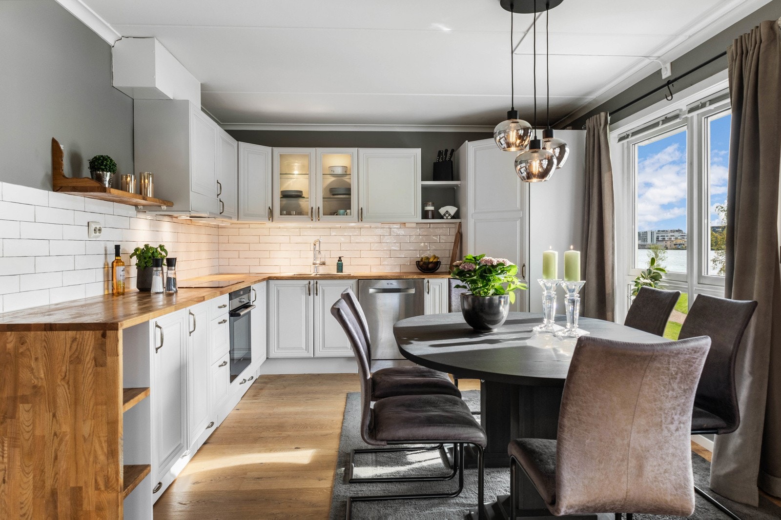 Moderne kjøkken med spiseplass og store vindusflater. Galleribilde