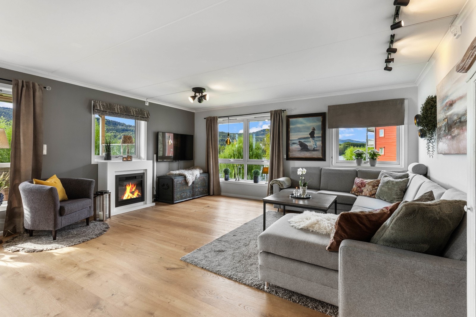 Lys og romslig stue med store vindusflater, flott utsikt og elektrisk peis. Galleribilde