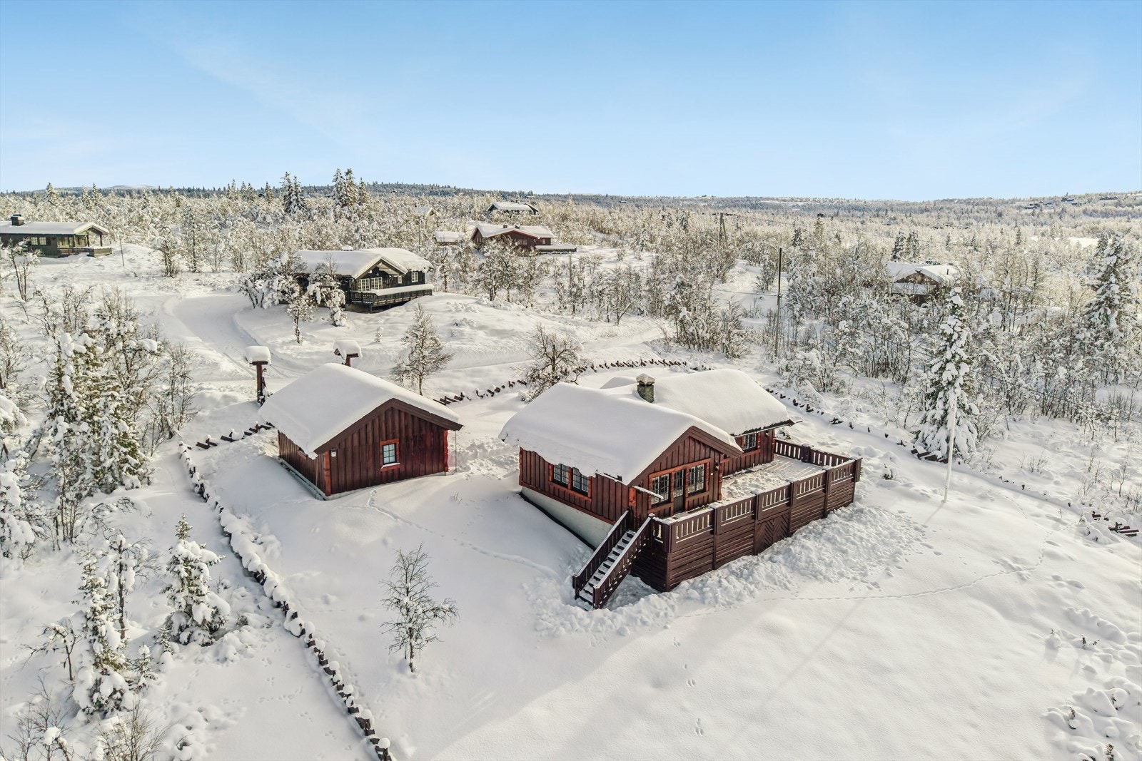 Hytta med tilhørende garasje ligger på en romslig og pent opparbeidet naturtomt hvor det er mulighet for flere hyggelige uteplasser. Deler av tomta er inngjerdet, og en flott port med belysning ønsker alle velkommen. Galleribilde