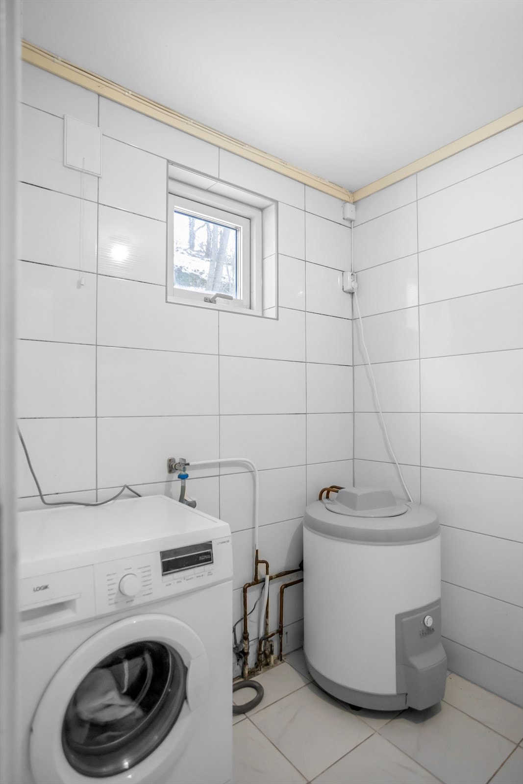 Vaskerommet har elektriske varmekabler og opplegg for vaskemaskin. Gulvet er flislagt, veggene har fliser og taket er malt. (Ikke omsøkt) Galleribilde