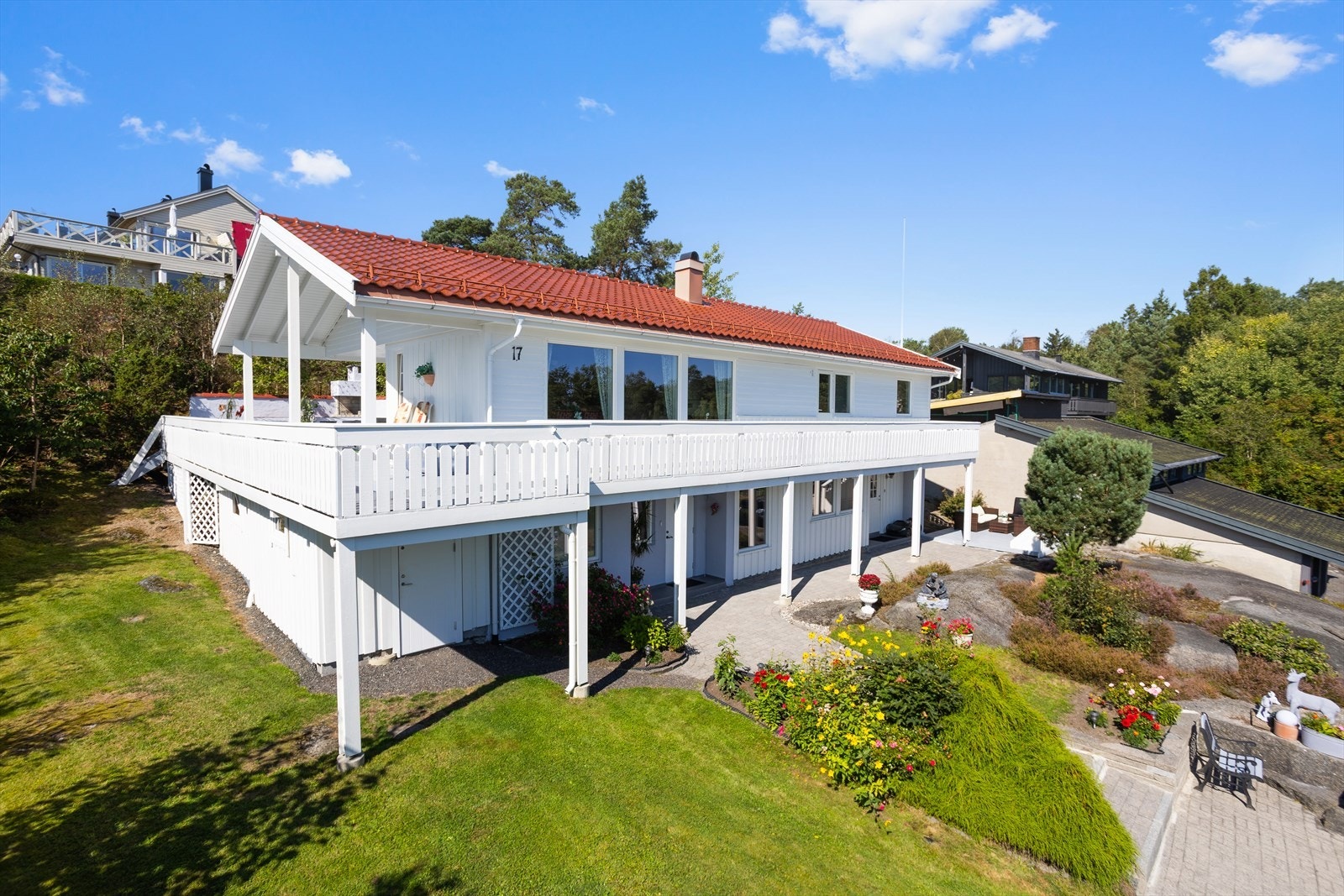 Inngangspartiet er omkranset av beplantning og plen, noe som gir en ryddig og tiltalende adkomst Galleribilde