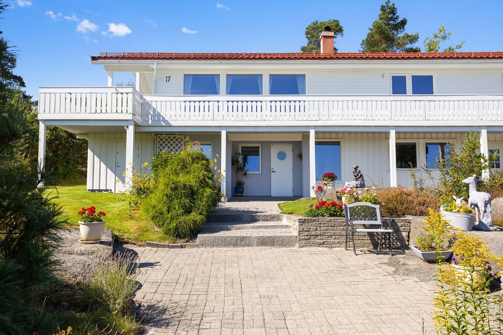 Sommerbildet viser eiendommen i grønne og trivelige omgivelser, med opparbeidet uteområde Galleribilde