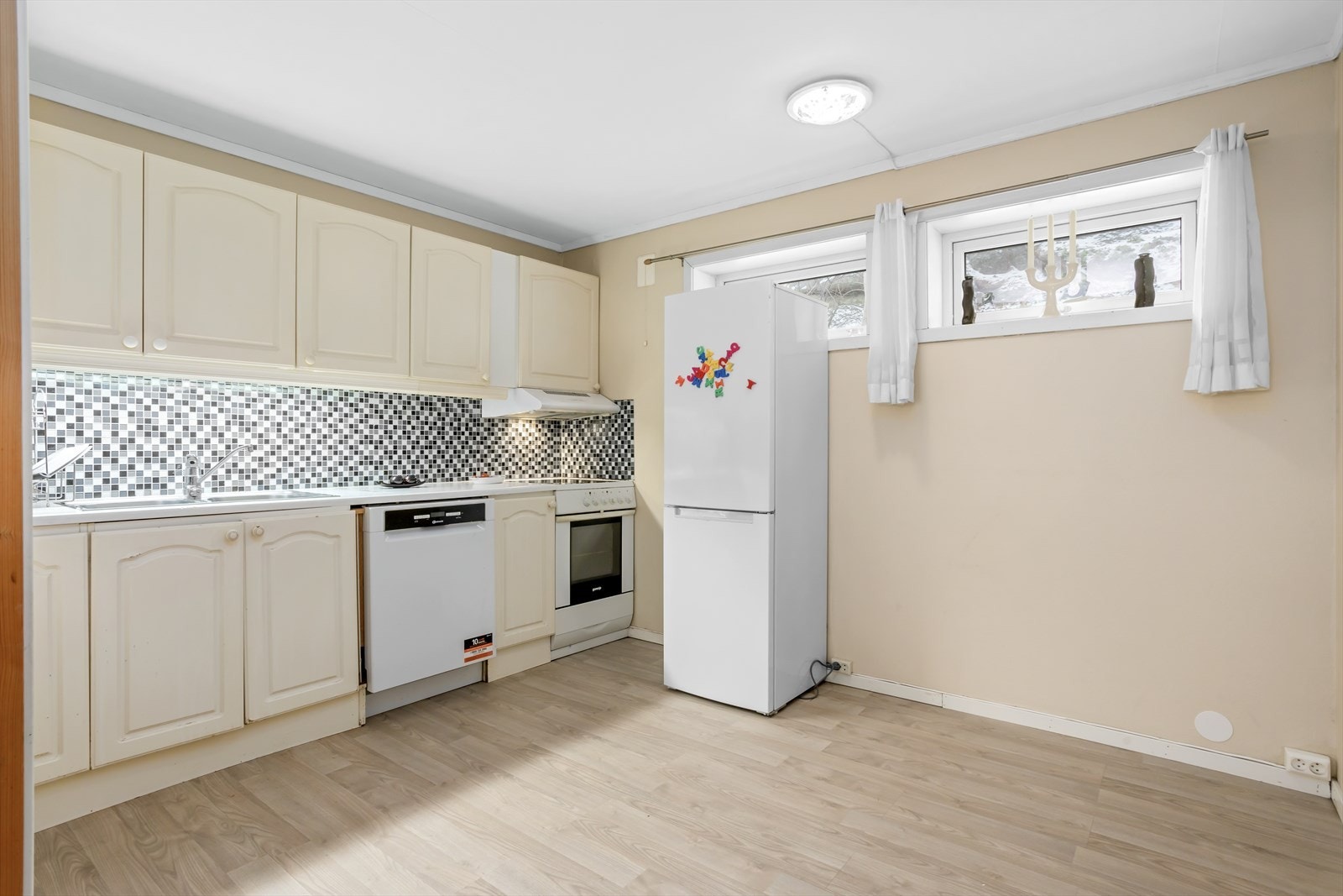 Kjøkkenet har innredning med profilerte fronter og laminert benkeplate Galleribilde