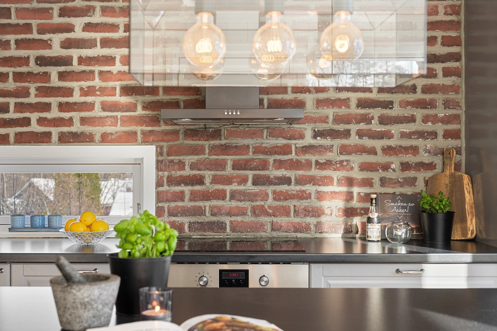 Vegg kledd med fasadestein over benken gir kjøkkenet et robust og stilig uttrykk. Galleribilde