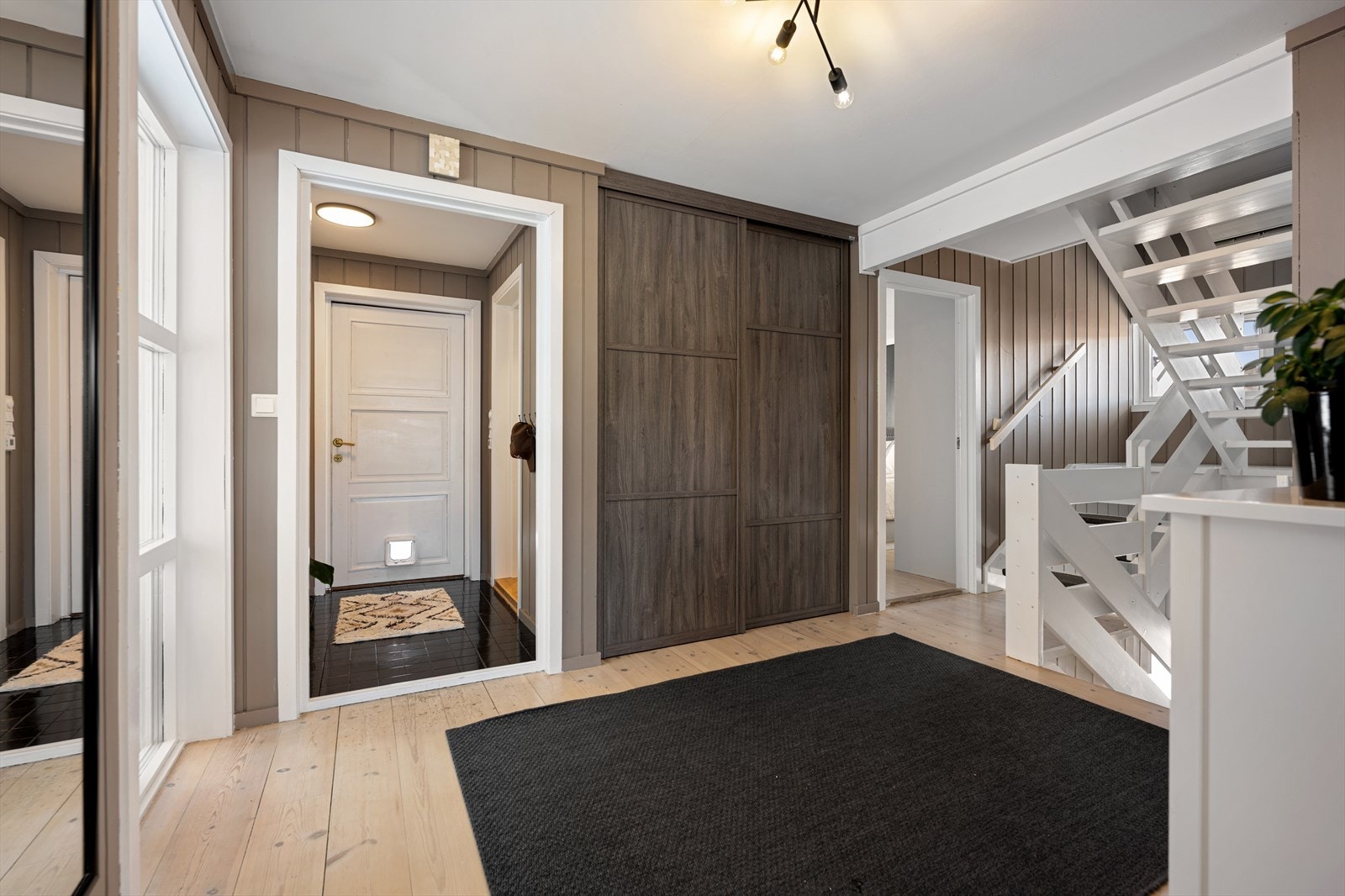 Videre kommer du til en meget romslig hall. Hallen er innredet med en stor skyvedørsgarderobe for ytterligere oppbevaring av yttertøy for en aktiv barnefamilie. Galleribilde