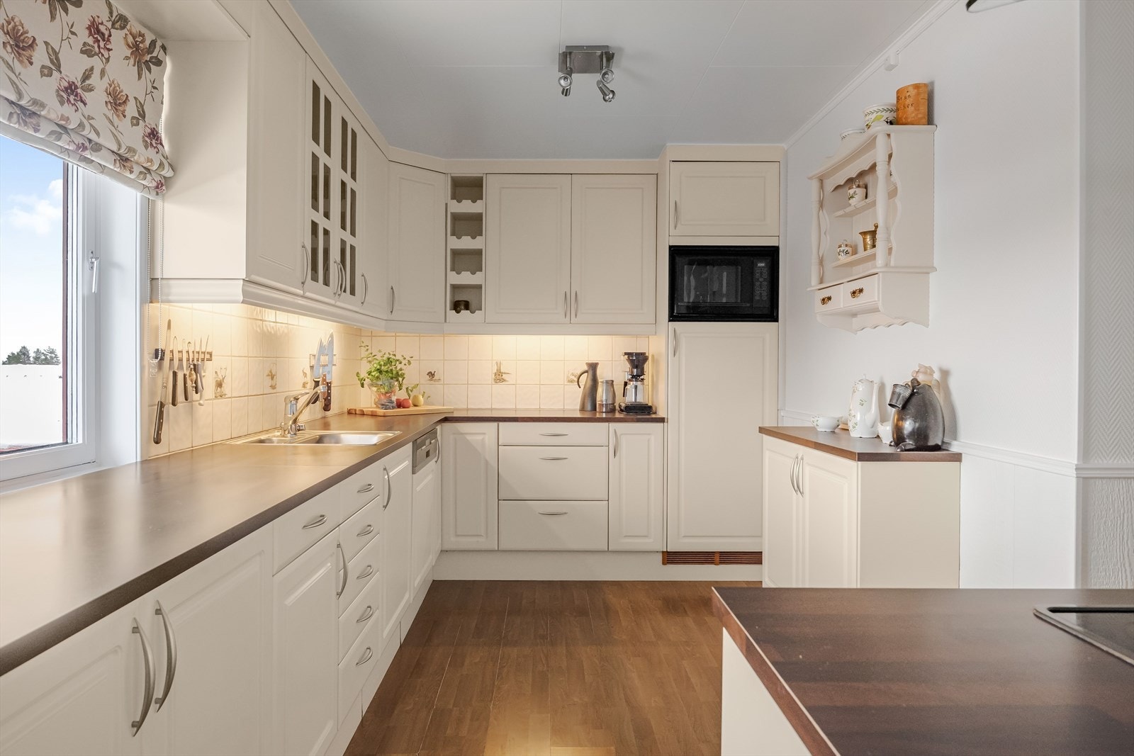 Kjøkken i hovedetasjen med integrerte hvitevarer som kjøleskap, mikro og oppvaskmaskin. Galleribilde