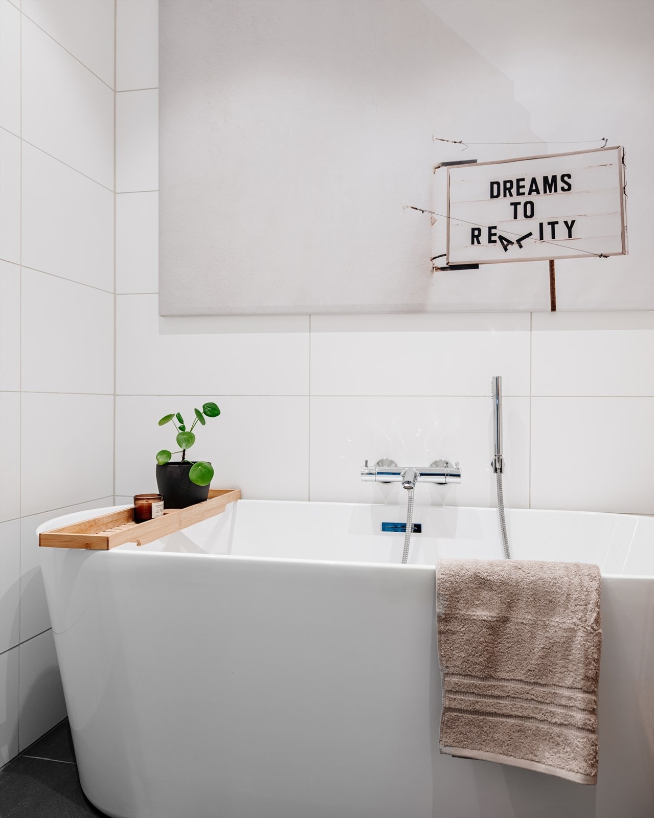 Badet er innredet med badekar, vegghengt toalett og en moderne baderomsinnredning. Speilskap med integrert LED-belysning Galleribilde