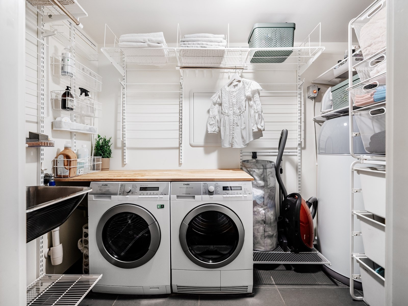 Romslig og funksjonelt vaskerom med flislagt gulv, elektriske varmekabler og malte veggflater Galleribilde