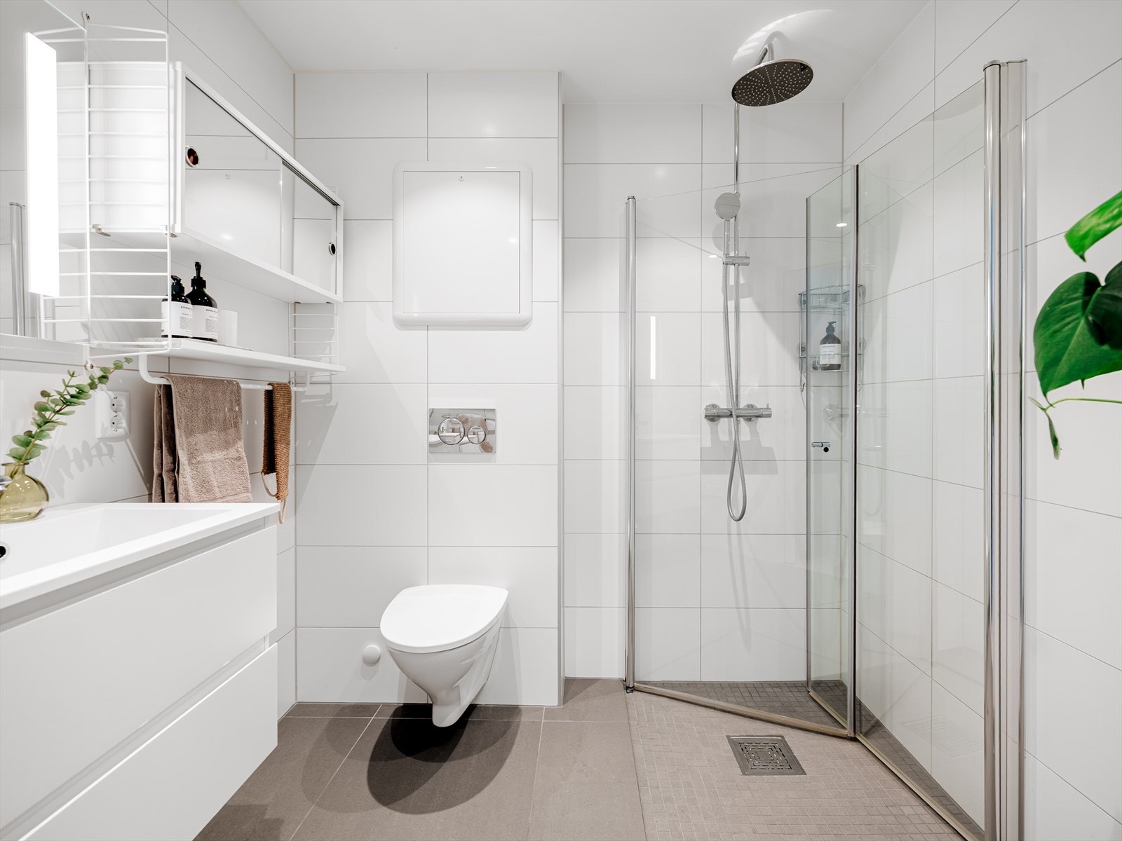 Etasjens 2. bad er helfliset, med varmekabler i gulv og downlights i himling Galleribilde