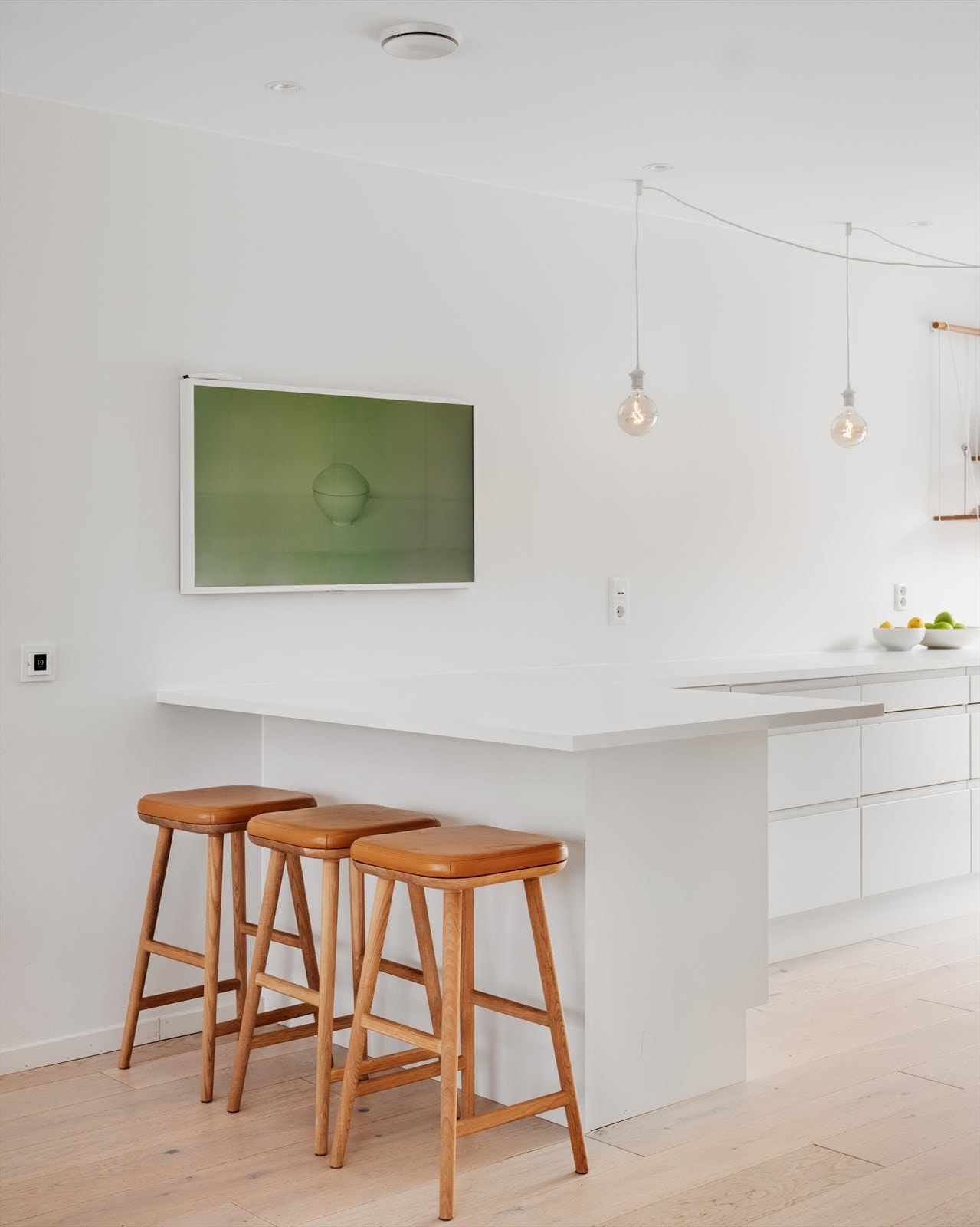 En halvøy med plass til barstoler skaper en uformell sone for raske måltider, samtidig som den legger til rette for sosial matlaging Galleribilde