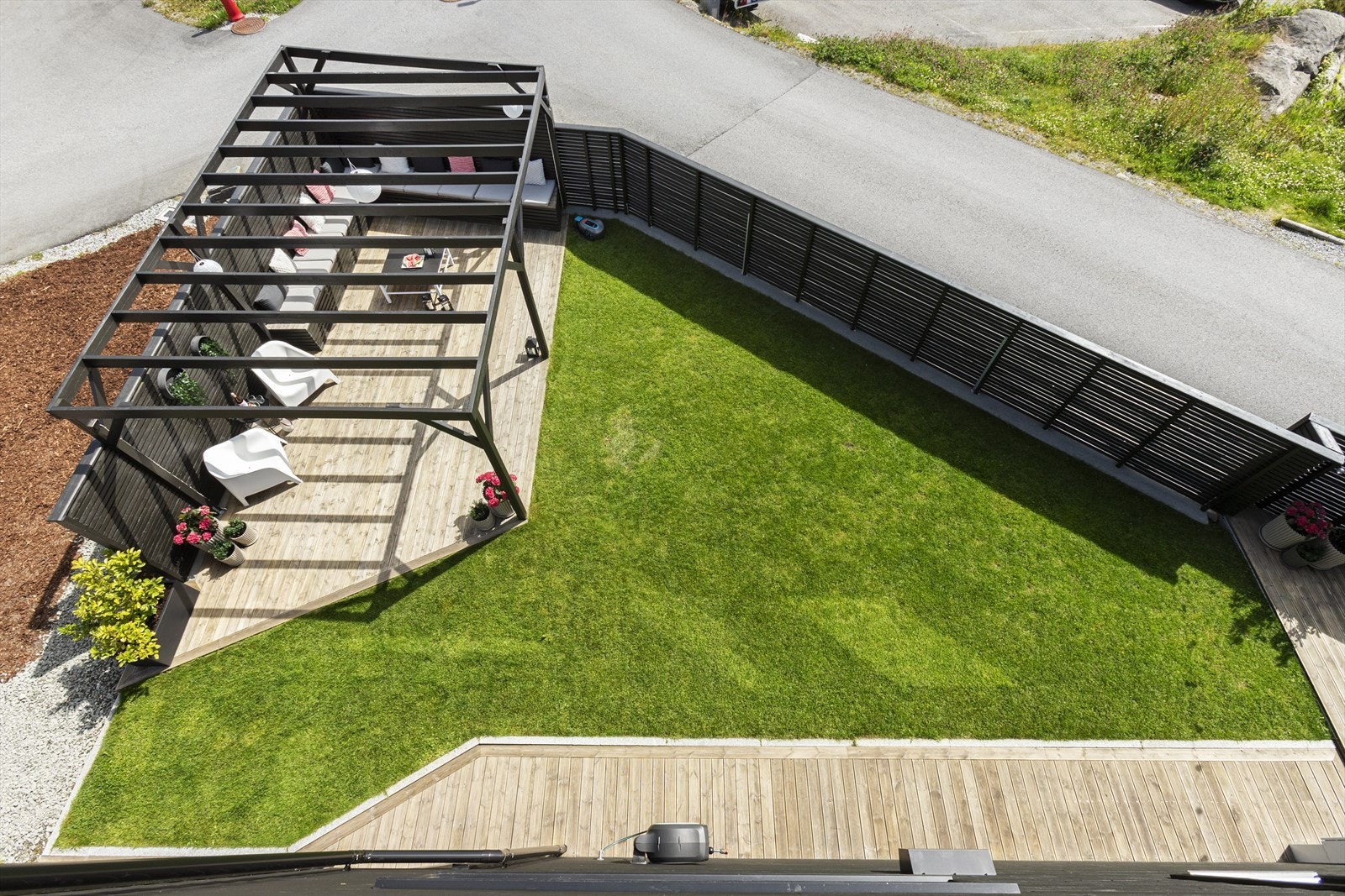 Her er det tilrettelagt med flere terrasser, levegger, plen, prydbusker og pergola. Galleribilde