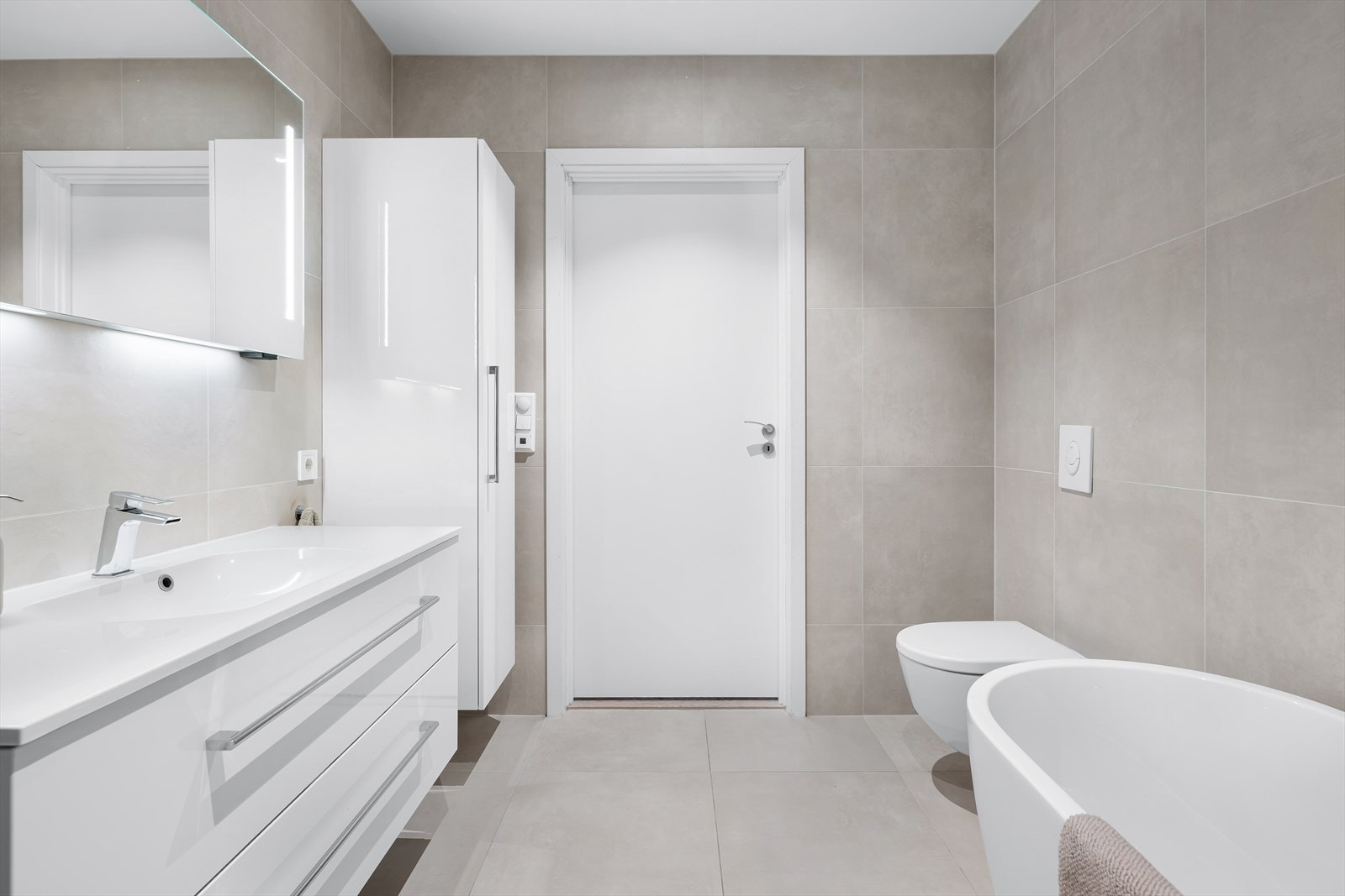 Her er det store fliser, badekar og god oppbevaringsplass i skuffer og skap. Galleribilde