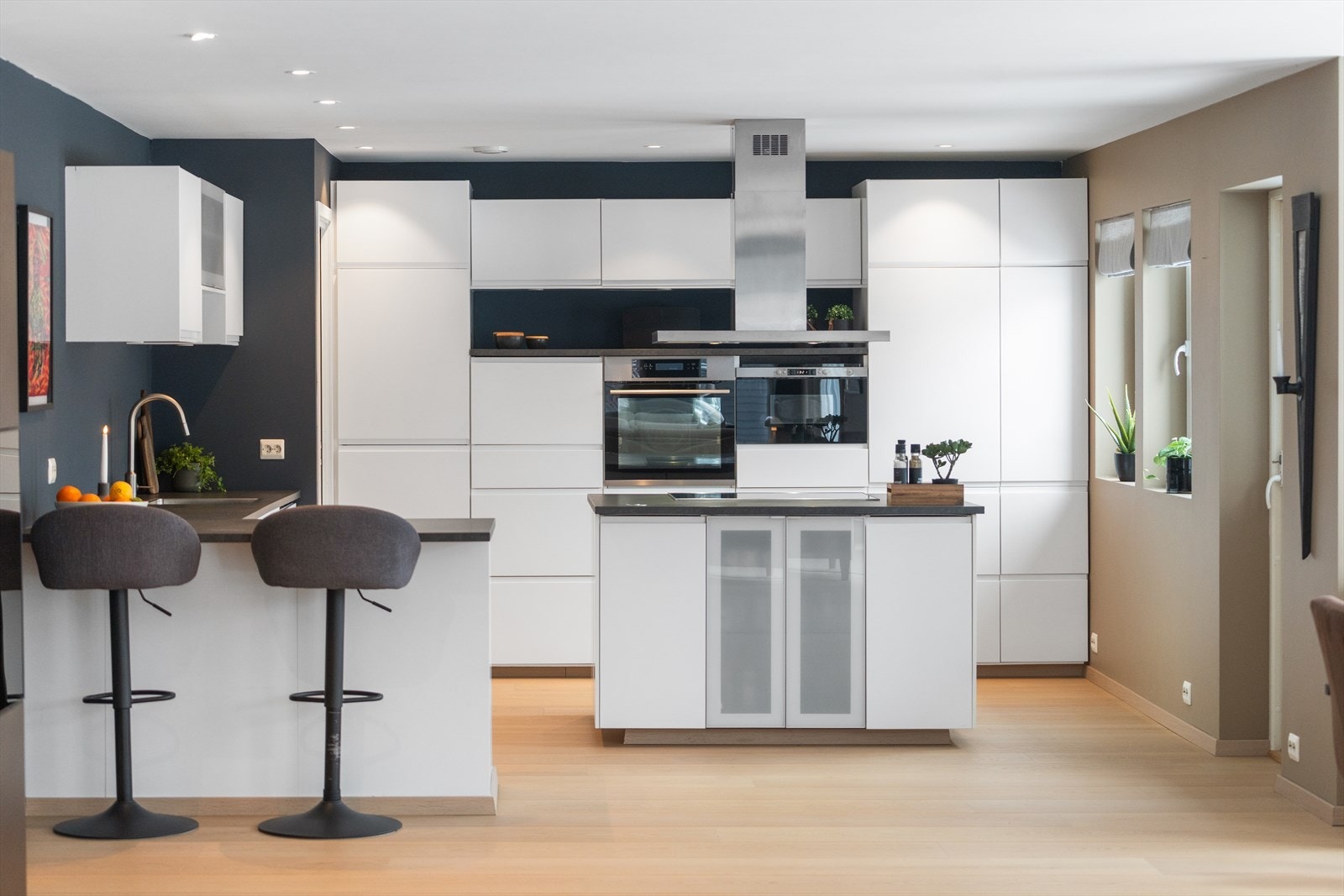 Kjøkkenet er delt inn i flere soner med både kjøkkenøy og halvøy Galleribilde