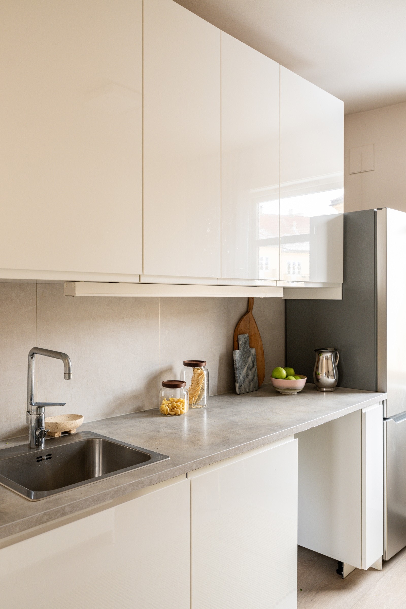 Lyst og moderne Ikea-kjøkken fra 2021 med god skap- og benkeplass. Innredningen har hvite glatte fronter og laminert benkeplate med nedfelt oppvaskkum. Både fint og praktisk med flotte fliser i benkeryggen og belysning under overskap. Galleribilde